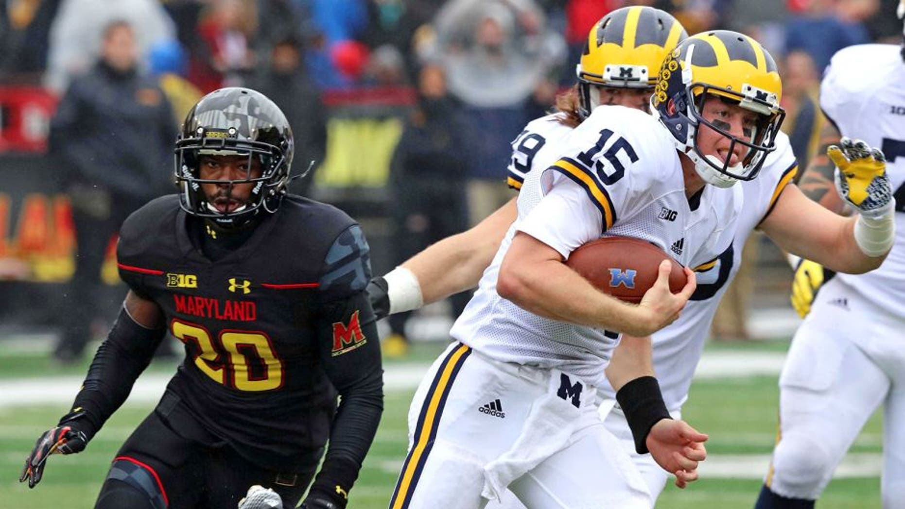 Oct 3, 2015; College Park, MD, USA; Michigan Wolverines quarterback Jake Rudock (15) runs for a gain past Maryland Terrapins defensive back Anthony Nixon (20) at Byrd Stadium. Mandatory Credit: Mitch Stringer-USA TODAY Sports