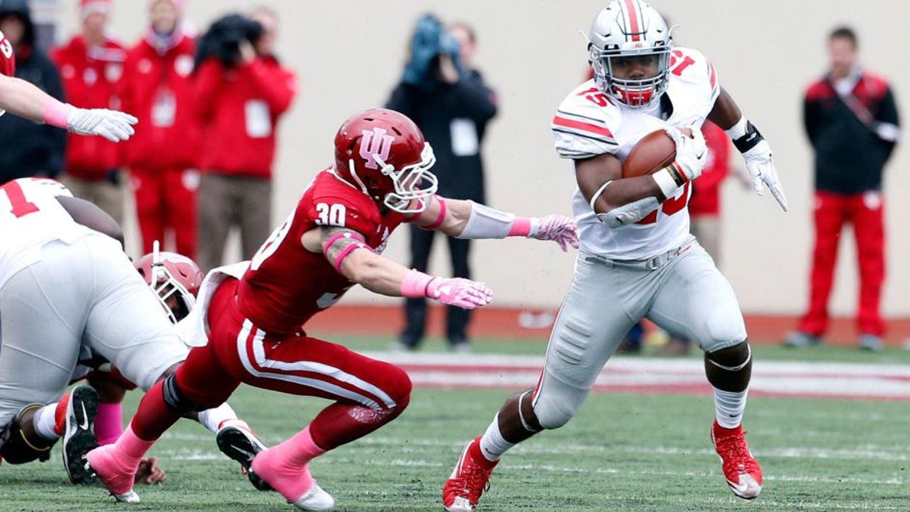 Oct 3, 2015; Bloomington, IN, USA; Ohio State Buckeyes running back Ezekiel Elliott (15) runs with the ball against Indiana Hoosiers safety Cjase Dutra (30) at Memorial Stadium. Mandatory Credit: Brian Spurlock-USA TODAY Sports