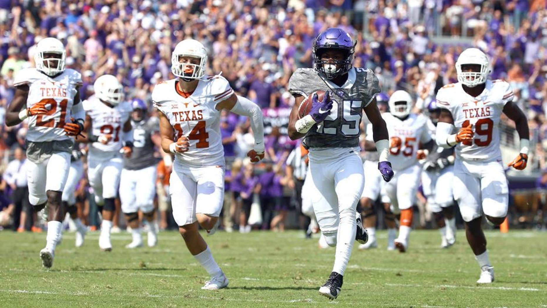 FORT WORTH, TX - OCTOBER 03: KaVontae Turpin #25 of the TCU Horned Frogs carries the ball for a touchdown against Duke Thomas #21 of the Texas Longhorns, Dylan Haines #14 of the Texas Longhorns, Peter Jinkens #19 of the Texas Longhorns in the second quarter at Amon G. Carter Stadium on October 3, 2015 in Fort Worth, Texas. (Photo by Tom Pennington/Getty Images)