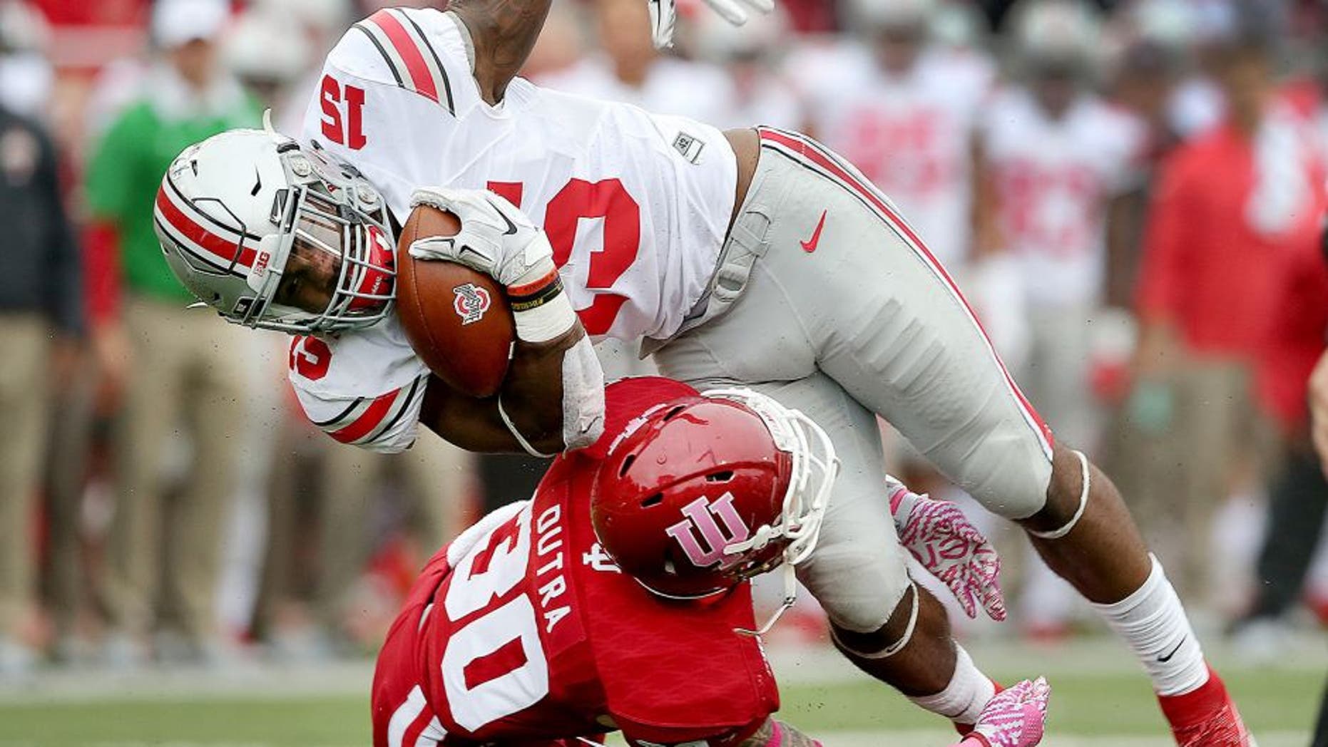 Oct 3, 2015; Bloomington, IN, USA; Ohio State Buckeyes running back Ezekiel Elliott (15) is stopped by Indiana Hoosiers defensive back Chase Dutra (30) in the first half of their game at Memorial Stadium. Mandatory Credit: Matt Kryger-USA TODAY Sports
