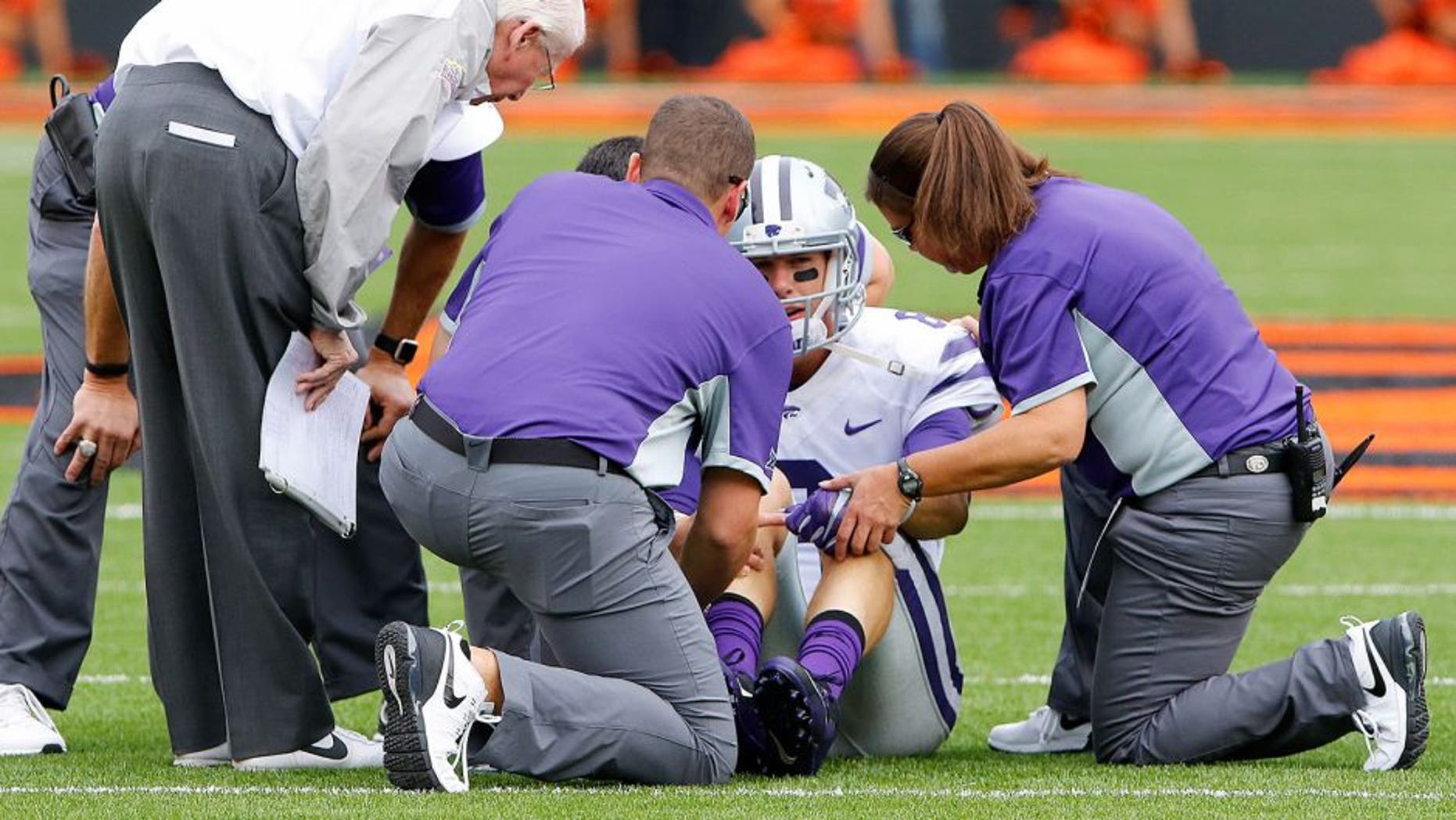 Oct 3, 2015; Stillwater, OK, USA; Kansas State Wildcats quarterback Joe Hubener (8) is looked at by trainers after getting injured in a play against the Oklahoma State Cowboys during the first quarter at Boone Pickens Stadium. Mandatory Credit: Alonzo Adams-USA TODAY Sports