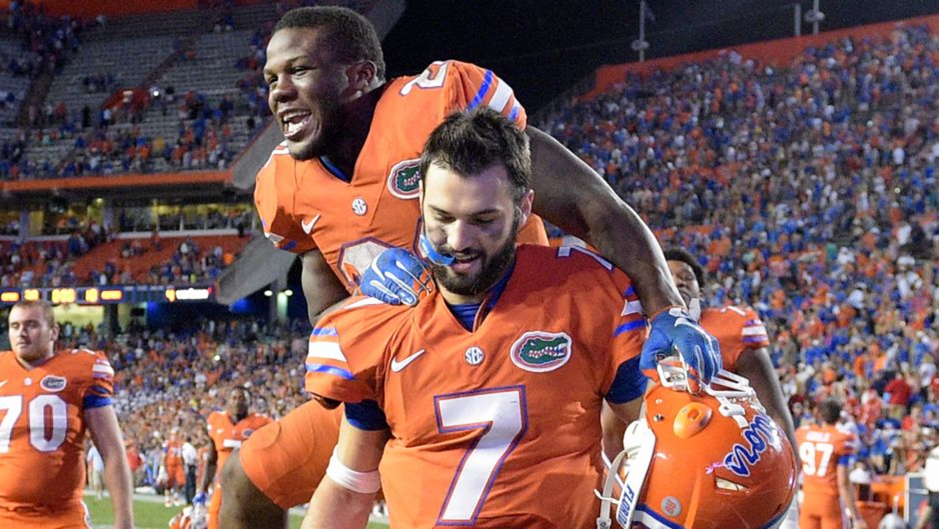 Florida running back Kelvin Taylor celebrates by jumping on quarterback Will Grier (7) after their 38-10 win over Mississippi in an NCAA college football game Saturday, Oct. 3, 2015, in Gainesville, Fla. (AP Photo/Phelan M. Ebenhack)