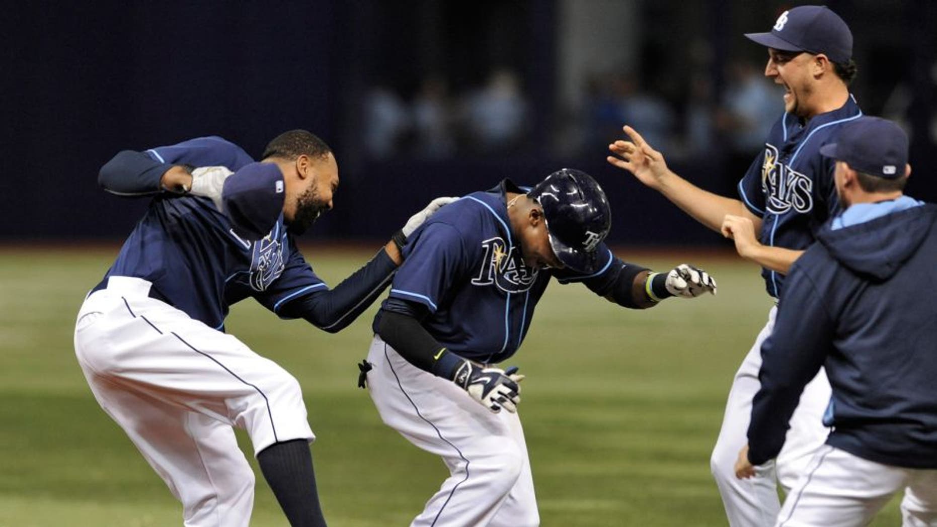 Tampa Bay Rays' Joey Butler, left, and Brad Boxberger, second from right, celebrate with Tim Beckham, center, after Beckham's two-run walk-off single to beat the Toronto Blue Jays 4-3 during the ninth inning of a baseball game Saturday, Oct. 3, 2015, in St. Petersburg, Fla. (AP Photo/Steve Nesius)