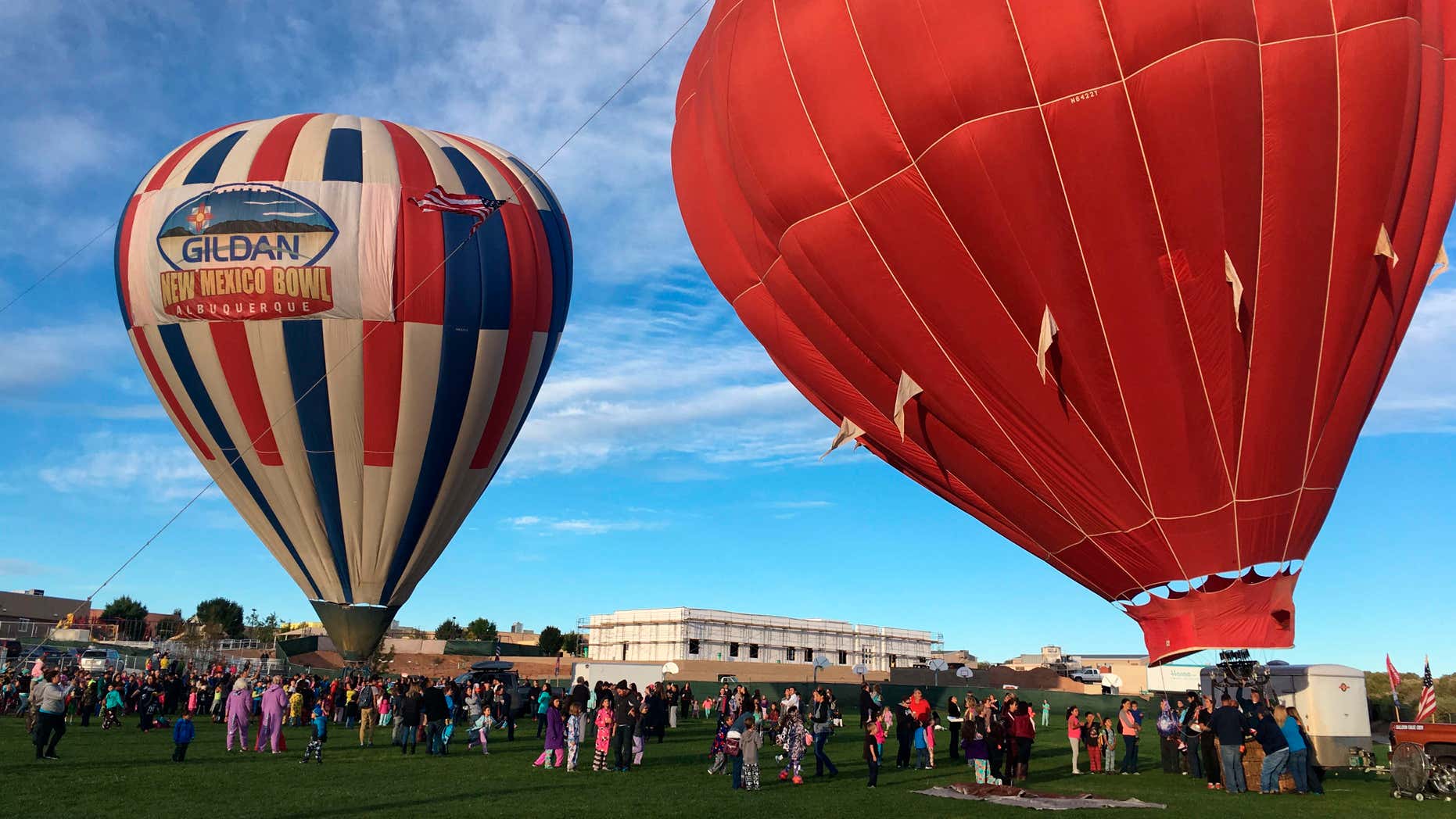 Two hot air balloons inflate at Vista Grande Elementary School in Rio Rancho, N.M. on Friday, Sept. 30, 2016, as part of the Albuquerque Aloft program that lifts balloons on school grounds as part of the 45th Albuquerque International Balloon Fiesta.
