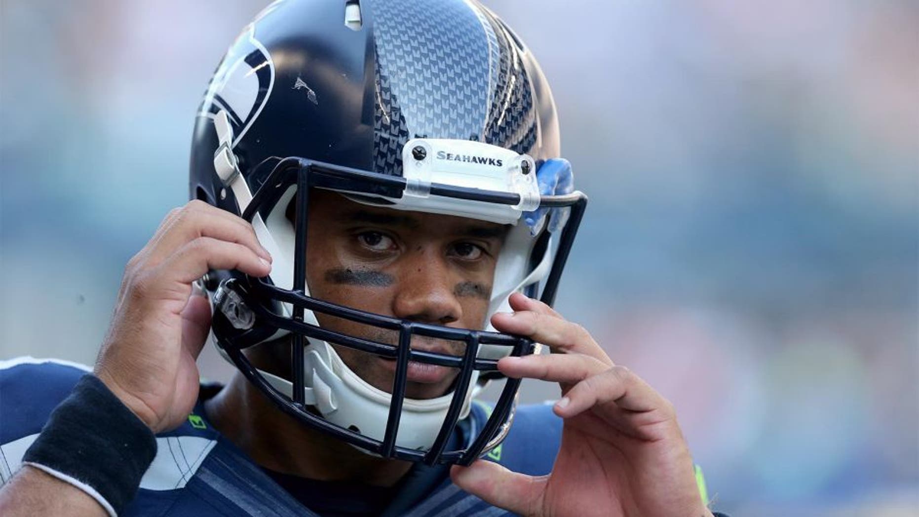 SEATTLE, WA - SEPTEMBER 21: Quarterback Russell Wilson #3 of the Seattle Seahawks adjusts his helmet against the Denver Broncos at CenturyLink Field on September 21, 2014 in Seattle, Washington. (Photo by Jeff Gross/Getty Images) *** Local Caption *** Russell Wilson