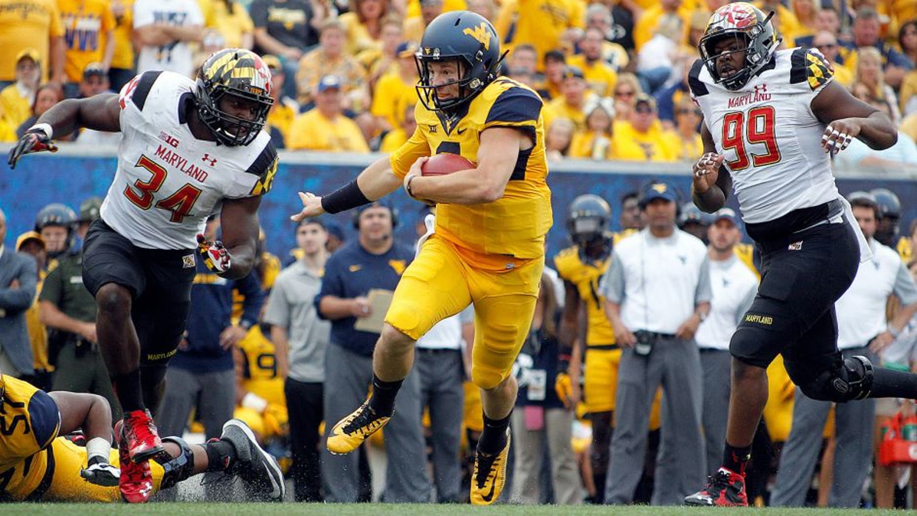 MORGANTOWN, WV - SEPTEMBER 26: Skyler Howard #3 of the West Virginia Mountaineers rushes against Quinton Jefferson #99 and Jefferson Ashiru #34 of the Maryland Terrapins during the game on September 26, 2015 at Mountaineer Field in Morgantown, West Virginia. (Photo by Justin K. Aller/Getty Images)