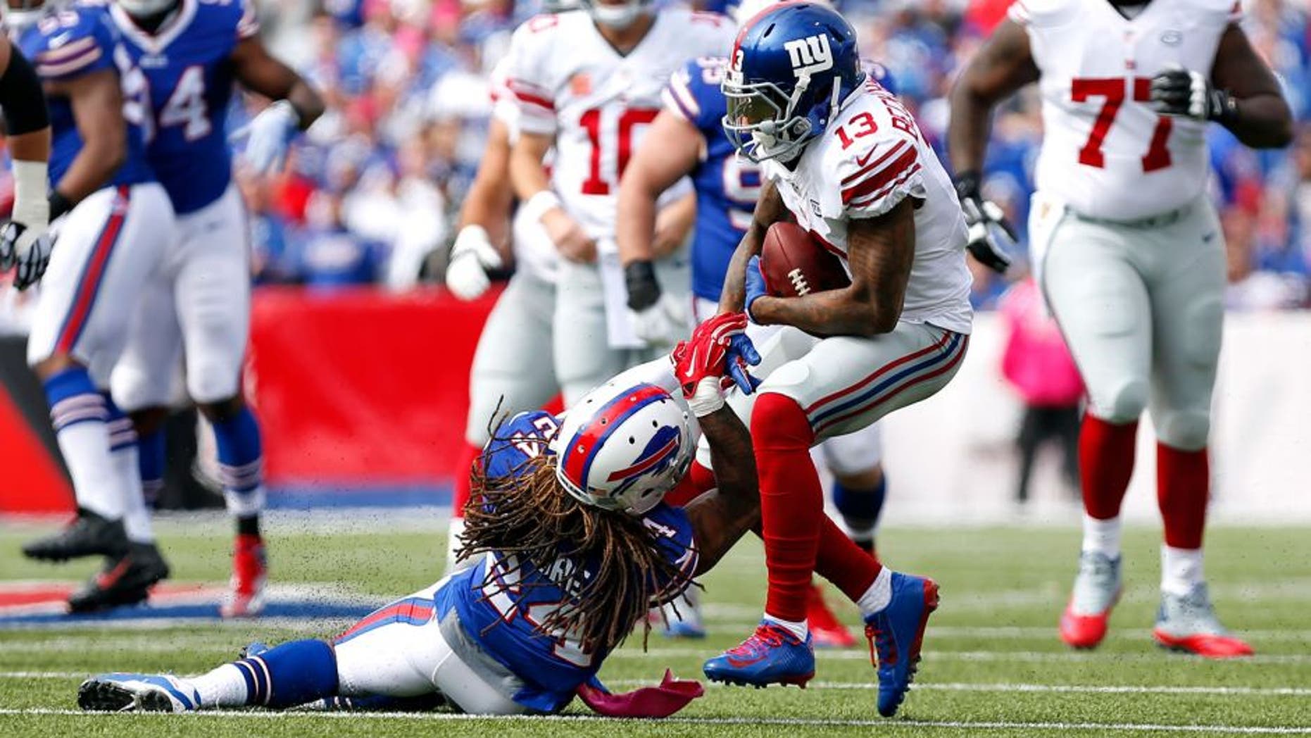 Oct 4, 2015; Orchard Park, NY, USA; New York Giants wide receiver Odell Beckham (13) runs after a catch and is tackled by Buffalo Bills cornerback Stephon Gilmore (24) during the first quarter at Ralph Wilson Stadium. Mandatory Credit: Kevin Hoffman-USA TODAY Sports