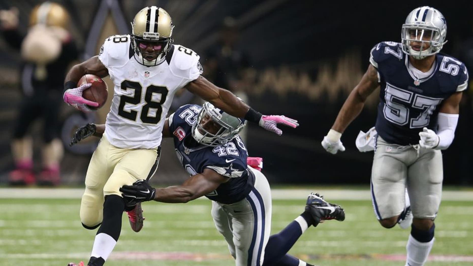 Oct 4, 2015; New Orleans, LA, USA; New Orleans Saints running back C.J. Spiller (28) breaks the tackle of Dallas Cowboys strong safety Barry Church (42) to score the game-winning 80-yard touchdown in overtime at Mercedes-Benz Superdome. The Saints won 26-20. Mandatory Credit: Chuck Cook-USA TODAY Sports