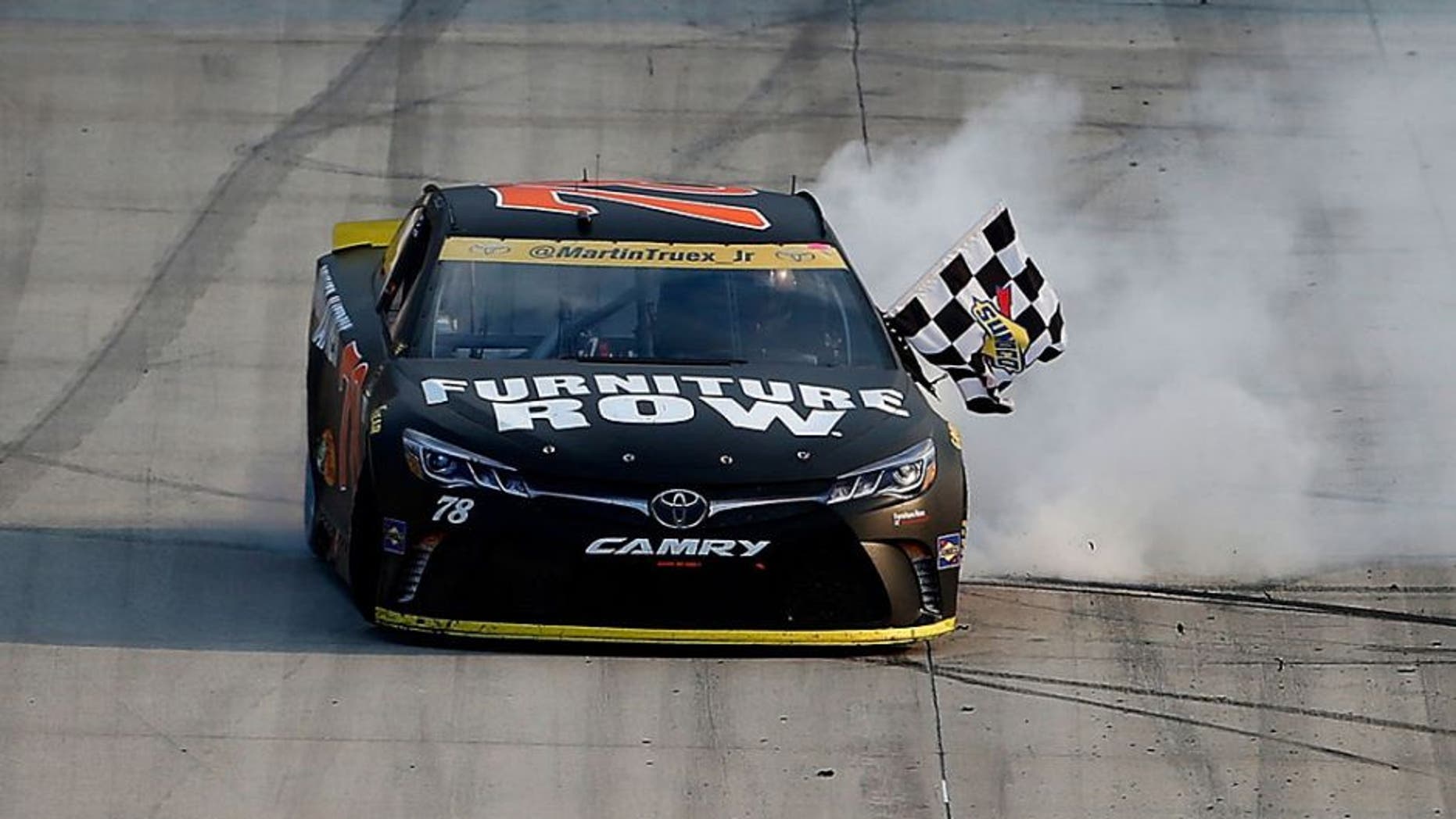 DOVER, DE - OCTOBER 02: Martin Truex Jr., driver of the #78 Furniture Row/Denver Mattress Toyota, celebrates with the checkered flag after winning the NASCAR Sprint Cup Series Citizen Solider 400 at Dover International Speedway on October 2, 2016 in Dover, Delaware. (Photo by Brian Lawdermilk/Getty Images)