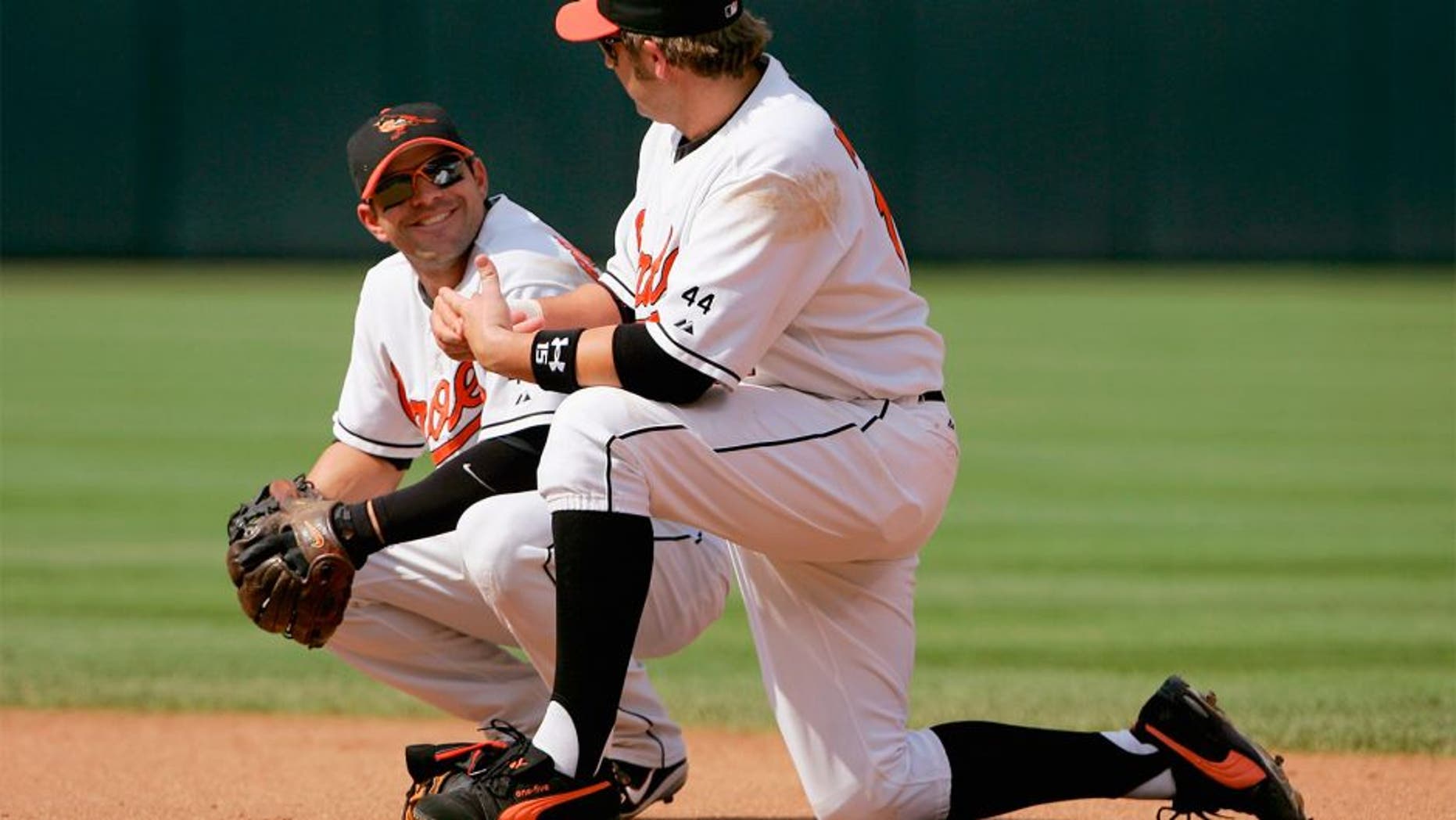 BALTIMORE - JUNE 04: First baseman Kevin Millar #15 and second baseman Brian Roberts #1 of the Baltimore Orioles chat as they await a pitching change against the New York Yankees as the Orioles defeated the Yankees 11-4 at Oriole Park at Camden Yards on June 4, 2006 in Baltimore, Maryland. (Photo by Doug Pensinger/Getty Images)