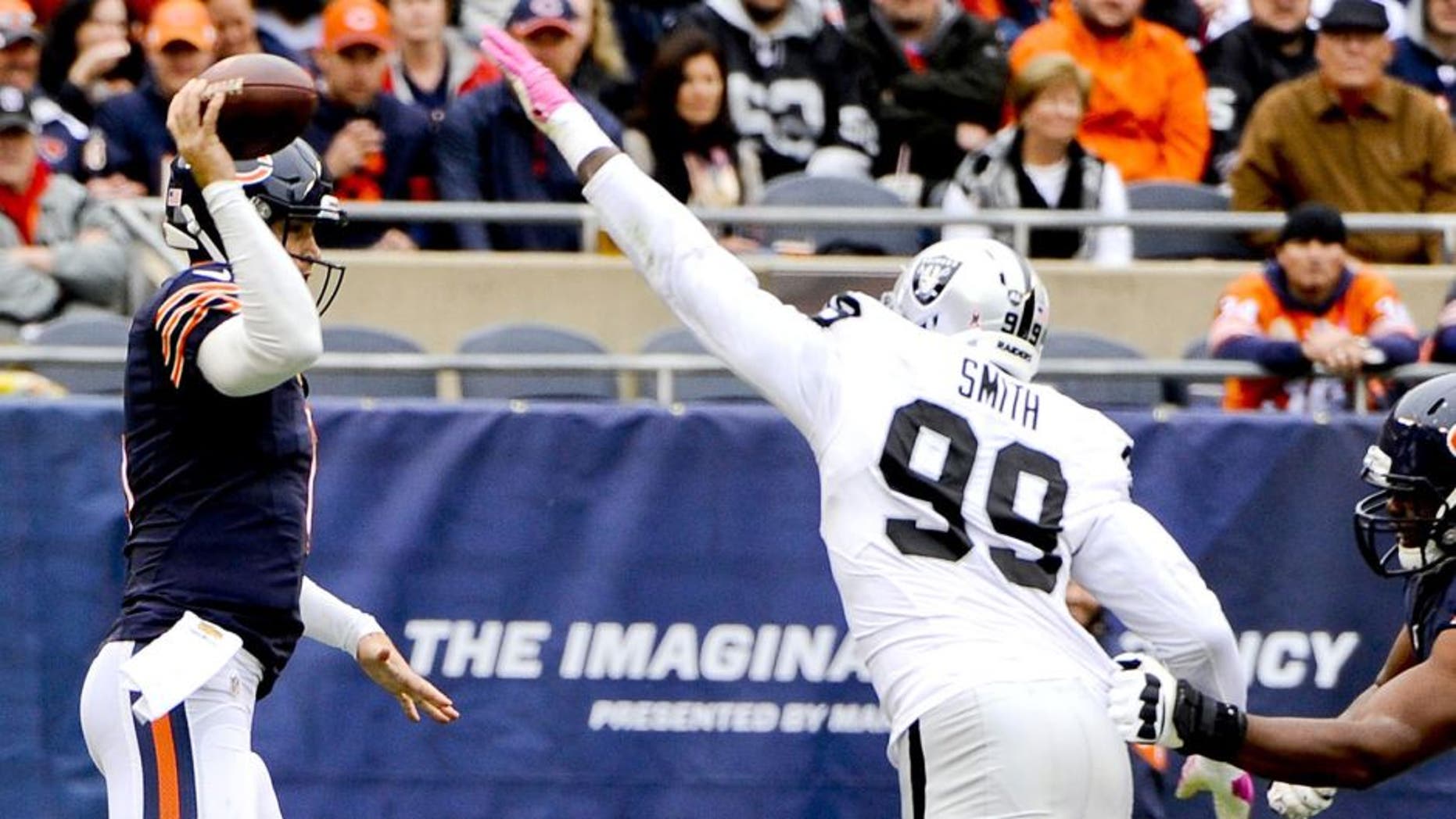 Oct 4, 2015; Chicago, IL, USA; Oakland Raiders outside linebacker Aldon Smith (99) tips the ball after Chicago Bears quarterback Jay Cutler (6) throws in the first quarter at Soldier Field. Mandatory Credit: Matt Marton-USA TODAY Sports