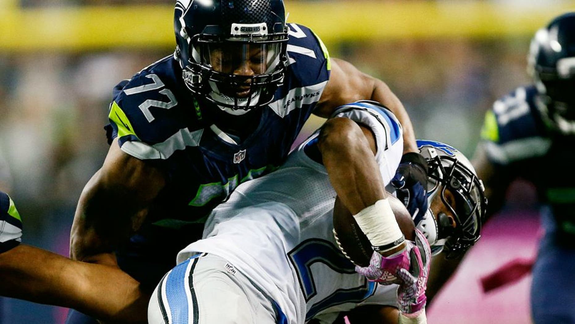 Oct 5, 2015; Seattle, WA, USA; Seattle Seahawks defensive end Michael Bennett (72) tackles Detroit Lions running back Ameer Abdullah (21) during the third quarter at CenturyLink Field. Mandatory Credit: Joe Nicholson-USA TODAY Sports