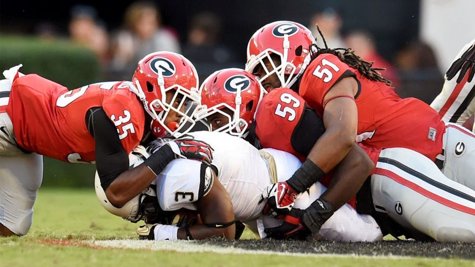 Oct 4, 2014; Athens, GA, USA; Vanderbilt Commodores running back Jerron Seymour (3) is tackled by Georgia Bulldogs cornerback Aaron Davis (35) linebacker Jordan Jenkins (59) and linebacker Ramik Wilson (51) during the second half at Sanford Stadium. Georgia defeated Vanderbilt 44-17. Mandatory Credit: Dale Zanine-USA TODAY Sports