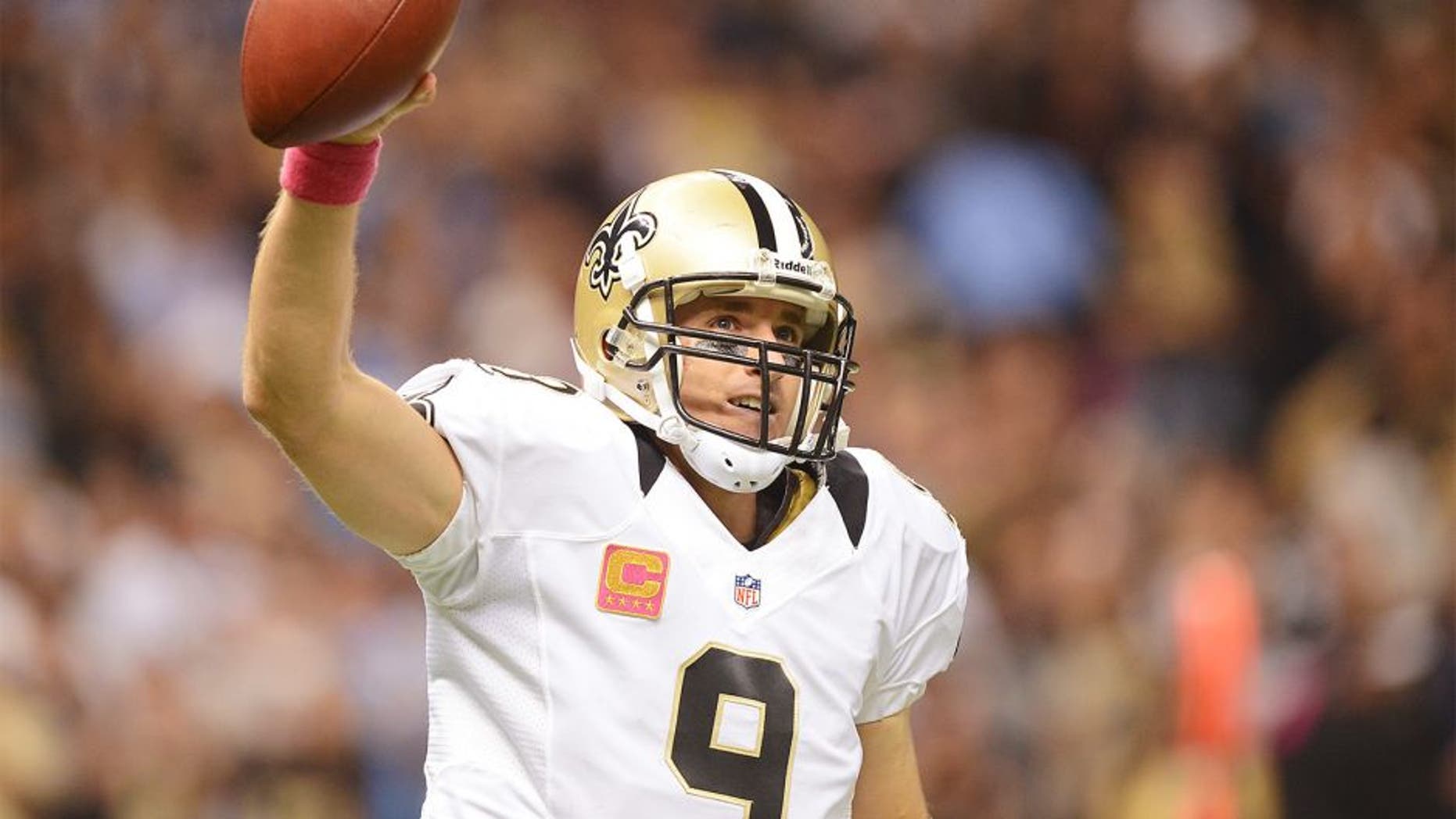 NEW ORLEANS, LA - OCTOBER 07: Quarterback Drew Brees #9 of the New Orleans Saints celebrates after his record breaking first quarter touchdown pass against the San Diego Chargers at Mercedes-Benz Superdome on October 7, 2012 in New Orleans, Louisiana. Brees has thrown a minimum of one touchdown pass in 48 straight regular season games. (Photo by Harry How/Getty Images)