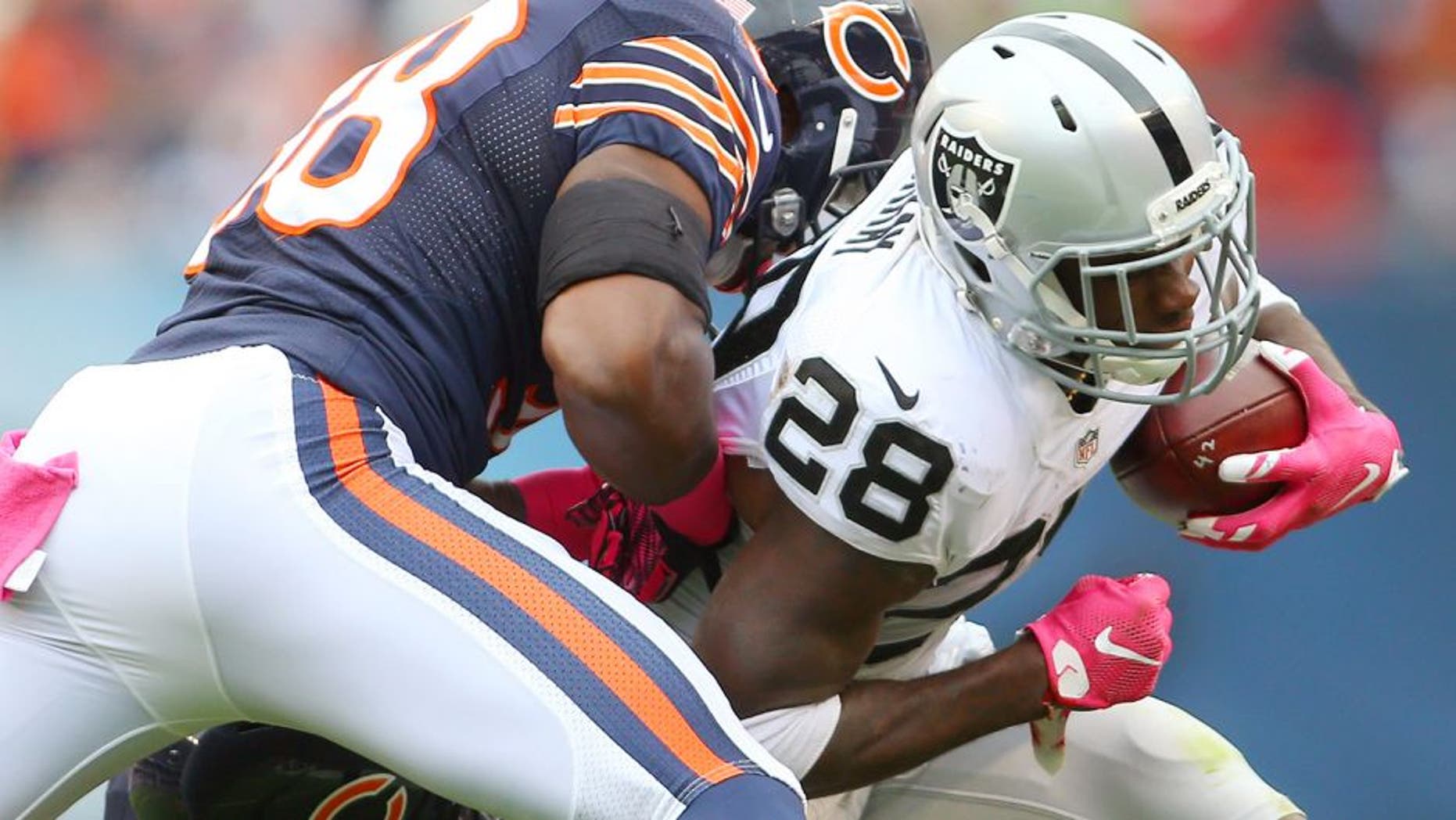 Oct 4, 2015; Chicago, IL, USA; Oakland Raiders running back Latavius Murray (28) is tackled by Chicago Bears free safety Adrian Amos (38) and linebacker Lamarr Houston (99) during the second quarter at Soldier Field. Mandatory Credit: Jerry Lai-USA TODAY Sports