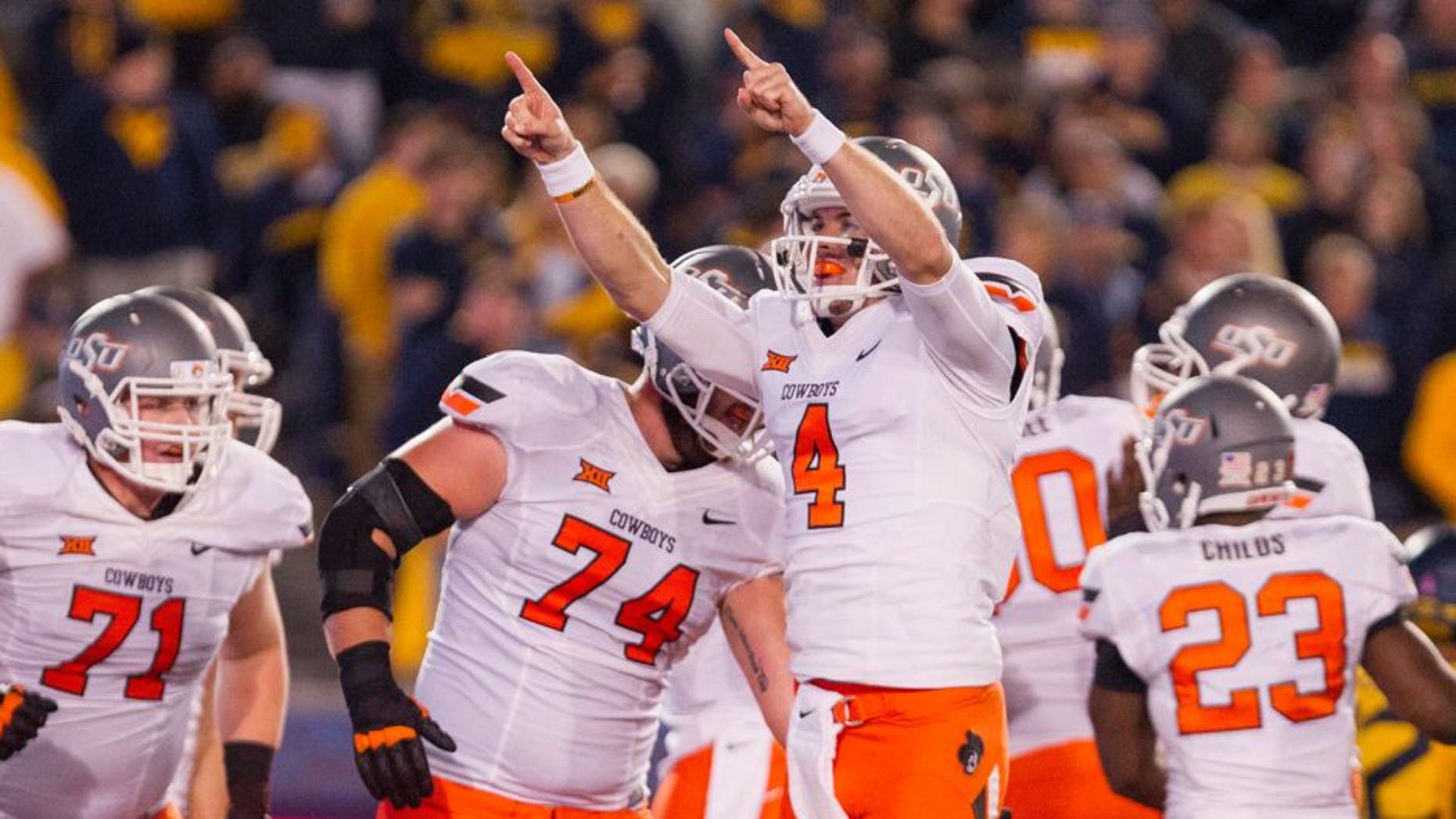 Oct 10, 2015; Morgantown, WV, USA; Oklahoma State Cowboys quarterback J.W Walsh celebrates after a touchdown during the third quarter against the West Virginia Mountaineers at Milan Puskar Stadium. Mandatory Credit: Ben Queen-USA TODAY Sports