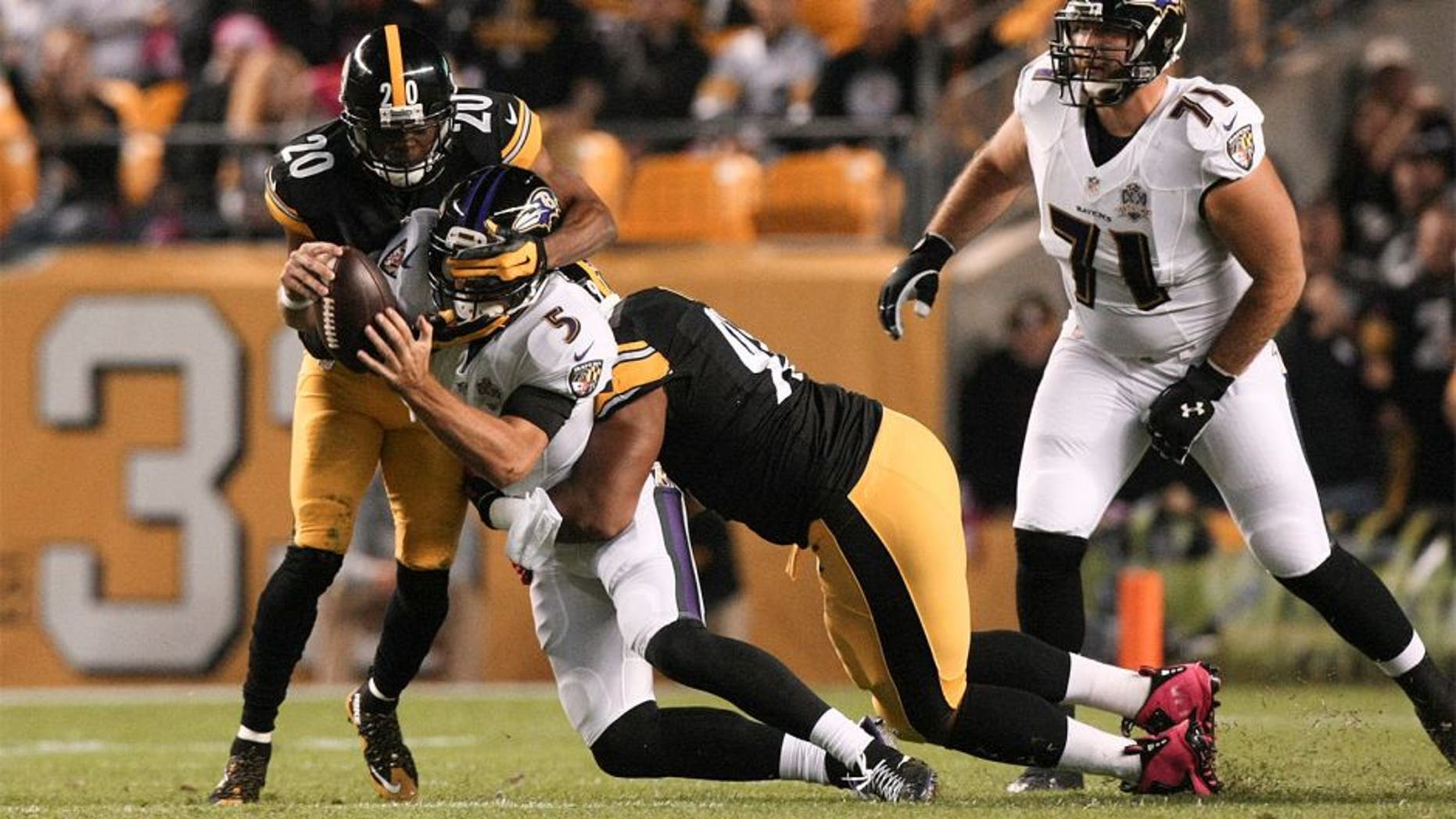 Oct 1, 2015; Pittsburgh, PA, USA; Baltimore Ravens quarterback Joe Flacco (5) is sacked by Pittsburgh Steelers safety Will Allen (20) and defensive end Stephon Tuitt (91) during the first quarter at Heinz Field. Mandatory Credit: Jason Bridge-USA TODAY Sports