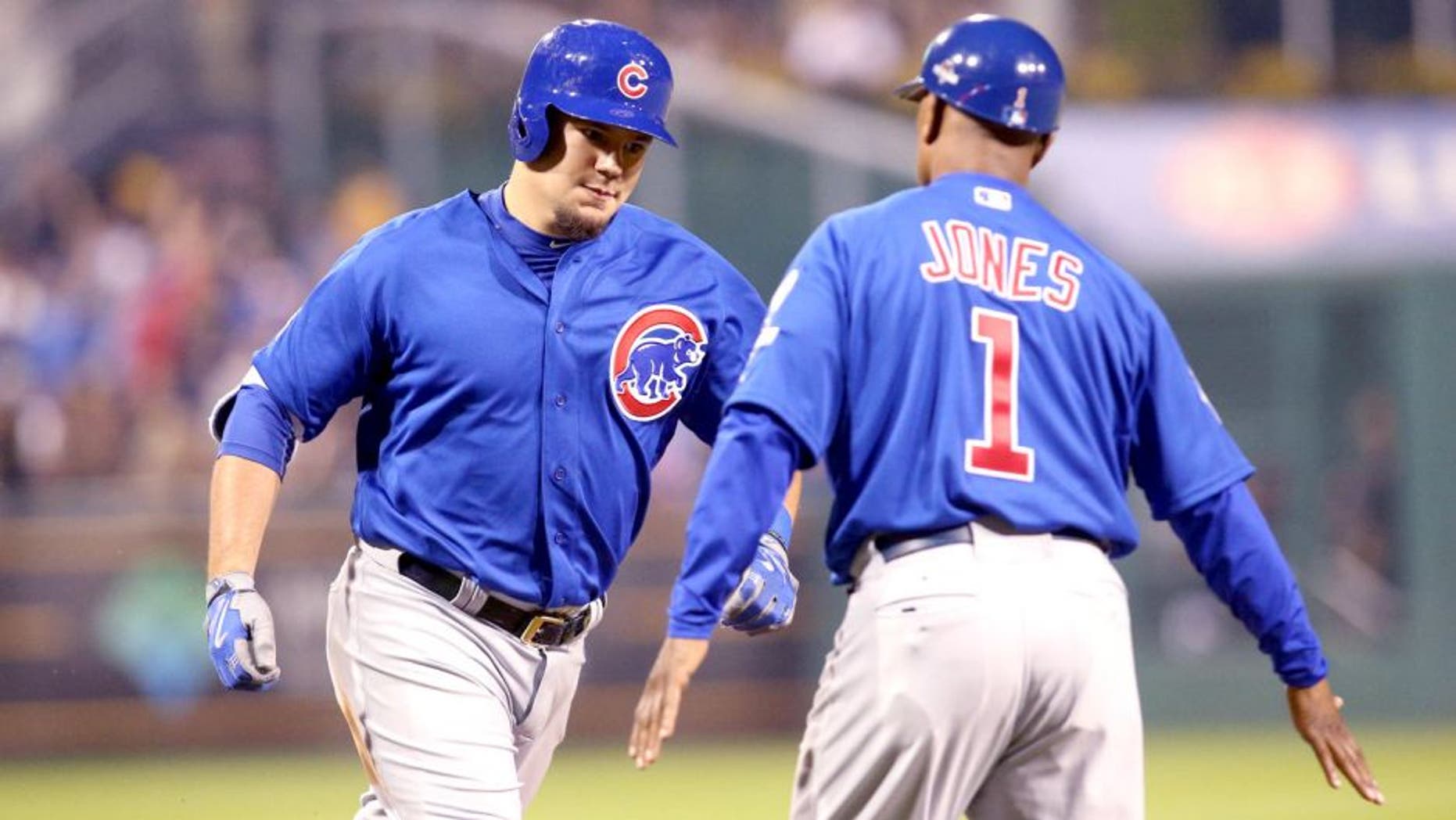 Oct 7, 2015; Pittsburgh, PA, USA; Chicago Cubs right fielder Kyle Schwarber (12) high fives third base coach Gary Jones (1) after hitting a two-run home run against the Pittsburgh Pirates during the third inning in the National League Wild Card playoff baseball game at PNC Park. Mandatory Credit: Charles LeClaire-USA TODAY Sports