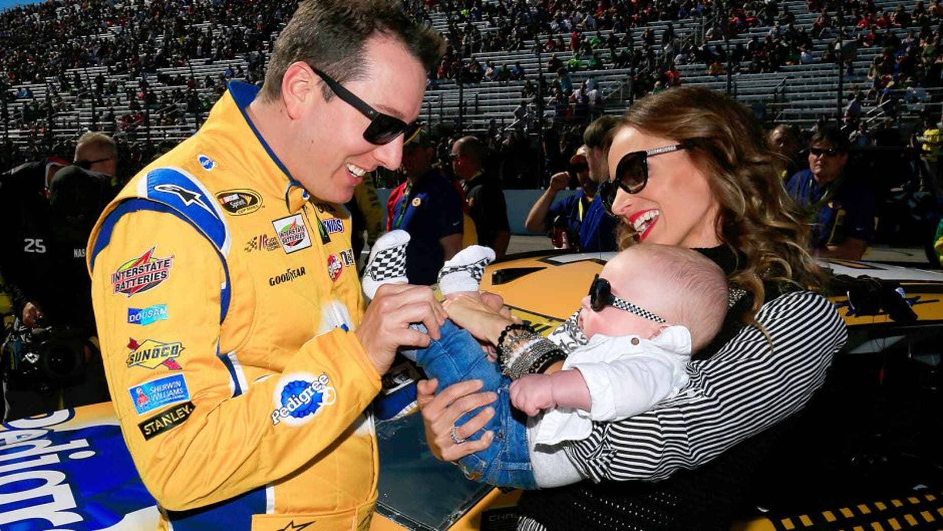 LOUDON, NH - SEPTEMBER 27: Kyle Busch, driver of the #18 Pedigree Toyota, stands on the grid with his wife, Samantha, and son, Brexton, prior to the NASCAR Sprint Cup Series SYLVANIA 300 at New Hampshire Motor Speedway on September 27, 2015 in Loudon, New Hampshire. (Photo by Chris Trotman/Getty Images)