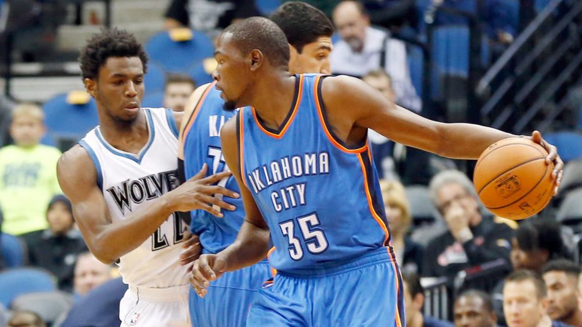 Oklahoma City Thunderâs Kevin Durant, right, drives as Enes Kanter sets a pick on Minnesota Timberwolvesâ Andrew Wiggins, left, in the first half of an NBA preseason basketball game Wednesday, Oct. 7, 2015, in Minneapolis. (AP Photo/Jim Mone)
