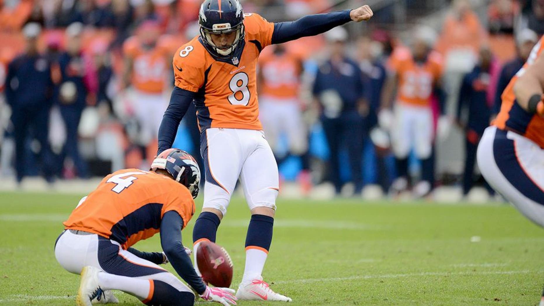 Oct 4, 2015; Denver, CO, USA; Denver Broncos kicker Brandon McManus (8) kicks the go ahead field goal as punter Britton Colquitt (4) holds late in the fourth quarter against the Minnesota Vikings at Sports Authority Field at Mile High. The Broncos defeated the Vikings 23-20. Mandatory Credit: Ron Chenoy-USA TODAY Sports