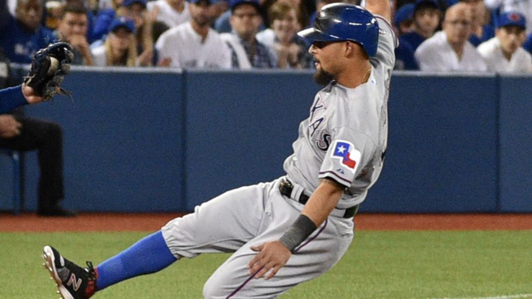 Oct 9, 2015; Toronto, Ontario, CAN; Texas Rangers second baseman Rougned Odor (12) slides into third base ahead of the tag by Toronto Blue Jays third baseman Josh Donaldson in the second inning in game two of the ALDS at Rogers Centre. Mandatory Credit: Nick Turchiaro-USA TODAY Sports