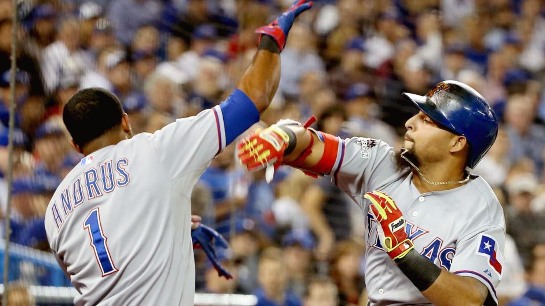 Rougned Odor #12 of the Texas Rangers celebrates with teammate Elvis Andrus #1 after scoring a solo home run against David Price #14 of the Toronto Blue Jays in the seventh inning during game one of the American League Division Series at Rogers Centre on October 8, 2015 in Toronto, Ontario, Canada. (Photo by Tom Szczerbowski/Getty Images)