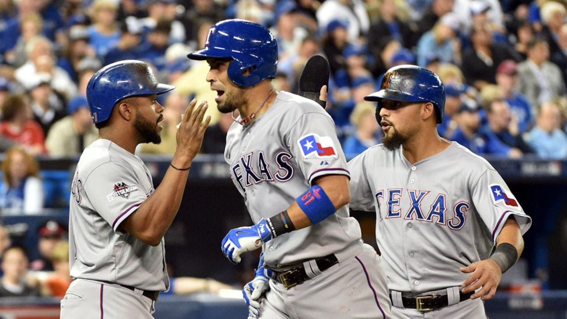 Oct 8, 2015; Toronto, Ontario, CAN; Texas Rangers catcher Robinson Chirinos (middle) celebrates with teammates Delino DeShields (left) and Rougned Odor (right) after hitting a two-run home run against the Toronto Blue Jays in the fifth inning in game one of the ALDS at Rogers Centre. Mandatory Credit: Nick Turchiaro-USA TODAY Sports