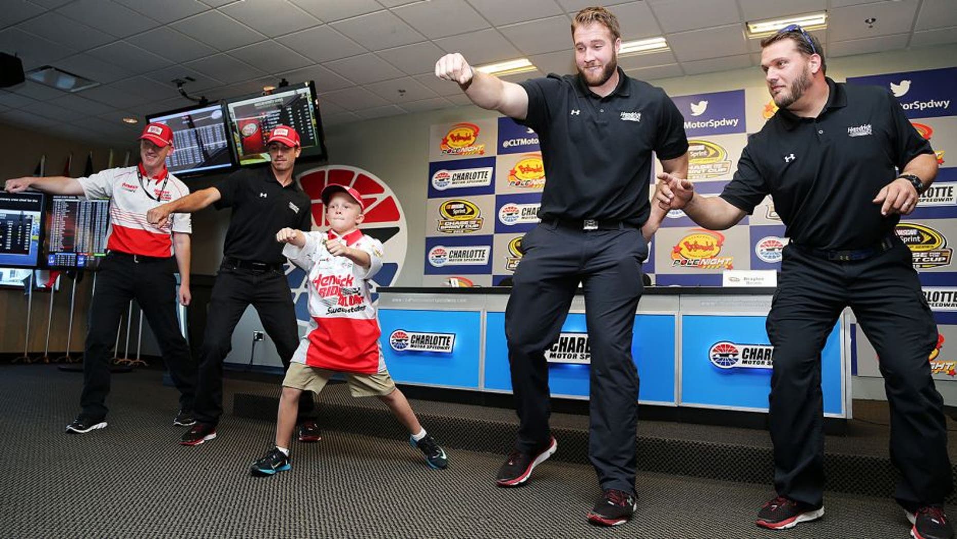 CHARLOTTE, NC - OCTOBER 08: Crew chief for Kasey Kahne, driver of the #5 HendrickRideAlong.com Chevrolet, Keith Rodden (L), crew members and honorary crew chief Braylon Beam (C) dance during a press conference prior to qualifying for the NASCAR Sprint Cup Series Bank of America 500 at Charlotte Motor Speedway on October 8, 2015 in Charlotte, North Carolina. (Photo by Jerry Markland/Getty Images)