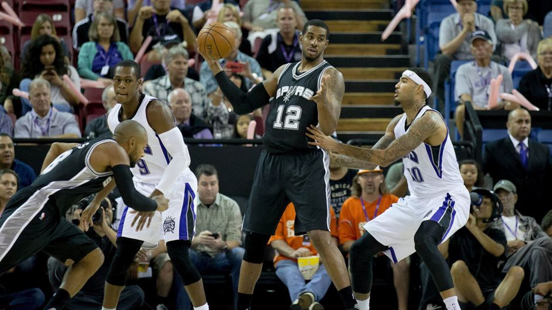 Oct 8, 2015; Sacramento, CA, USA; San Antonio Spurs forward LaMarcus Aldridge (12) dribbles the ball as Sacramento Kings center Willie Cauley-Stein (00) defends during the first quarter at Sleep Train Arena. Mandatory Credit: Kelley L Cox-USA TODAY Sports