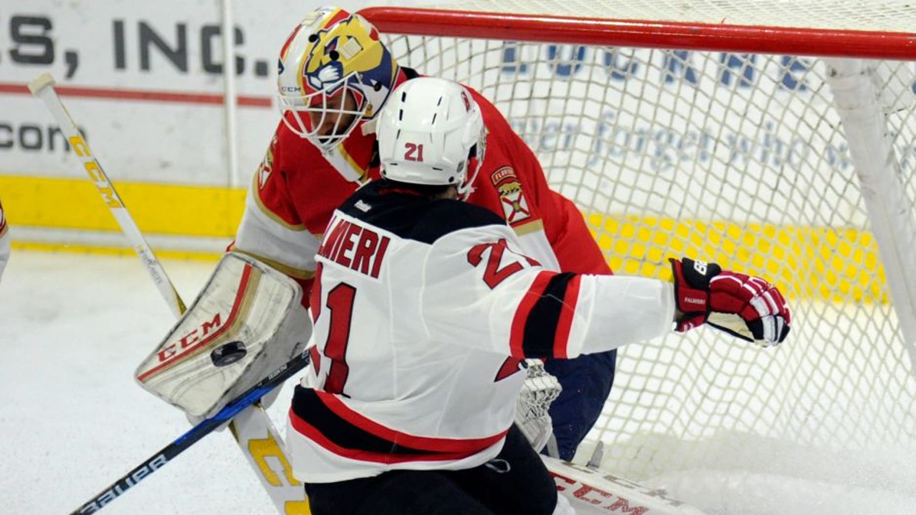 Florida Panthers goalie Roberto Luongo (1) deflects a shot by New Jersey Devils right wing Kyle Palmieri (21) during the first period of an NHL preseason hockey game, Saturday, Oct. 8, 2016, in West Point, N.Y. (AP Photo/Hans Pennink)