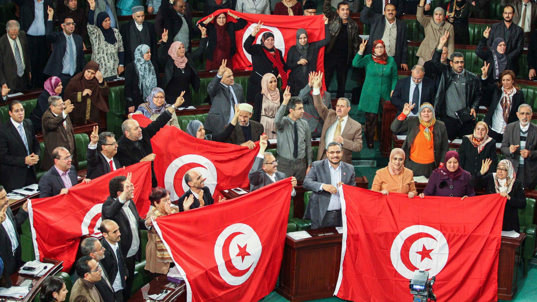 FILE - In this Sunday, Jan. 26, 2014 file photo, members of the Tunisian National Constituent Assembly celebrate the adoption of the new constitution in Tunis, Tunisia.