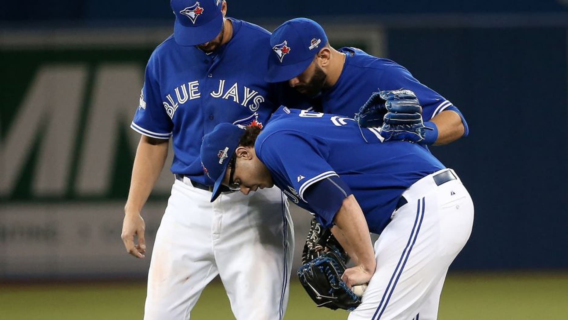 TORONTO, ON - OCTOBER 09: Brett Cecil #27 of the Toronto Blue Jays is helped by teammates after a tag out to end the top of the eighth inning against the Texas Rangers during game two of the American League Division Series at Rogers Centre on October 9, 2015 in Toronto, Canada. (Photo by Tom Szczerbowski/Getty Images)