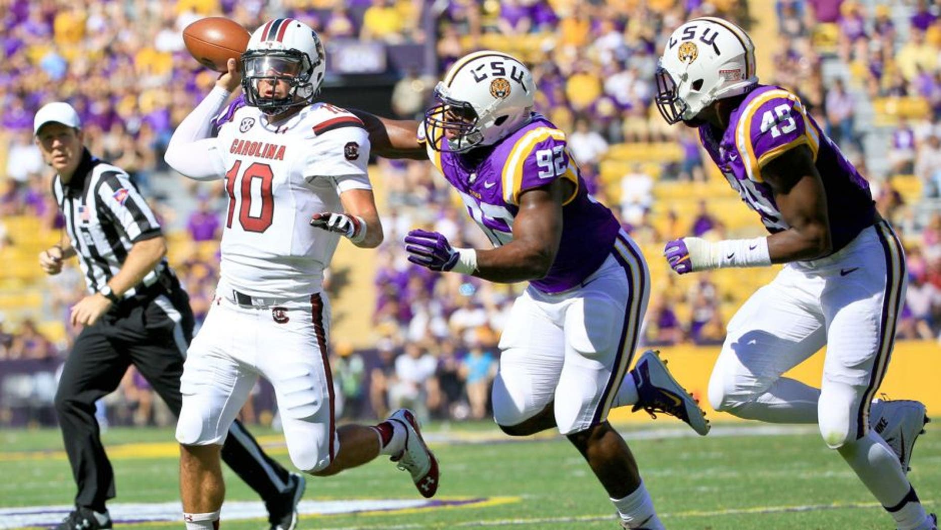 Oct 10, 2015; Baton Rouge, LA, USA; South Carolina Gamecocks quarterback Perry Orth (10) is pressured by LSU Tigers defensive end Lewis Neal (92) during the first quarter of a game at Tiger Stadium. Mandatory Credit: Derick E. Hingle-USA TODAY Sports