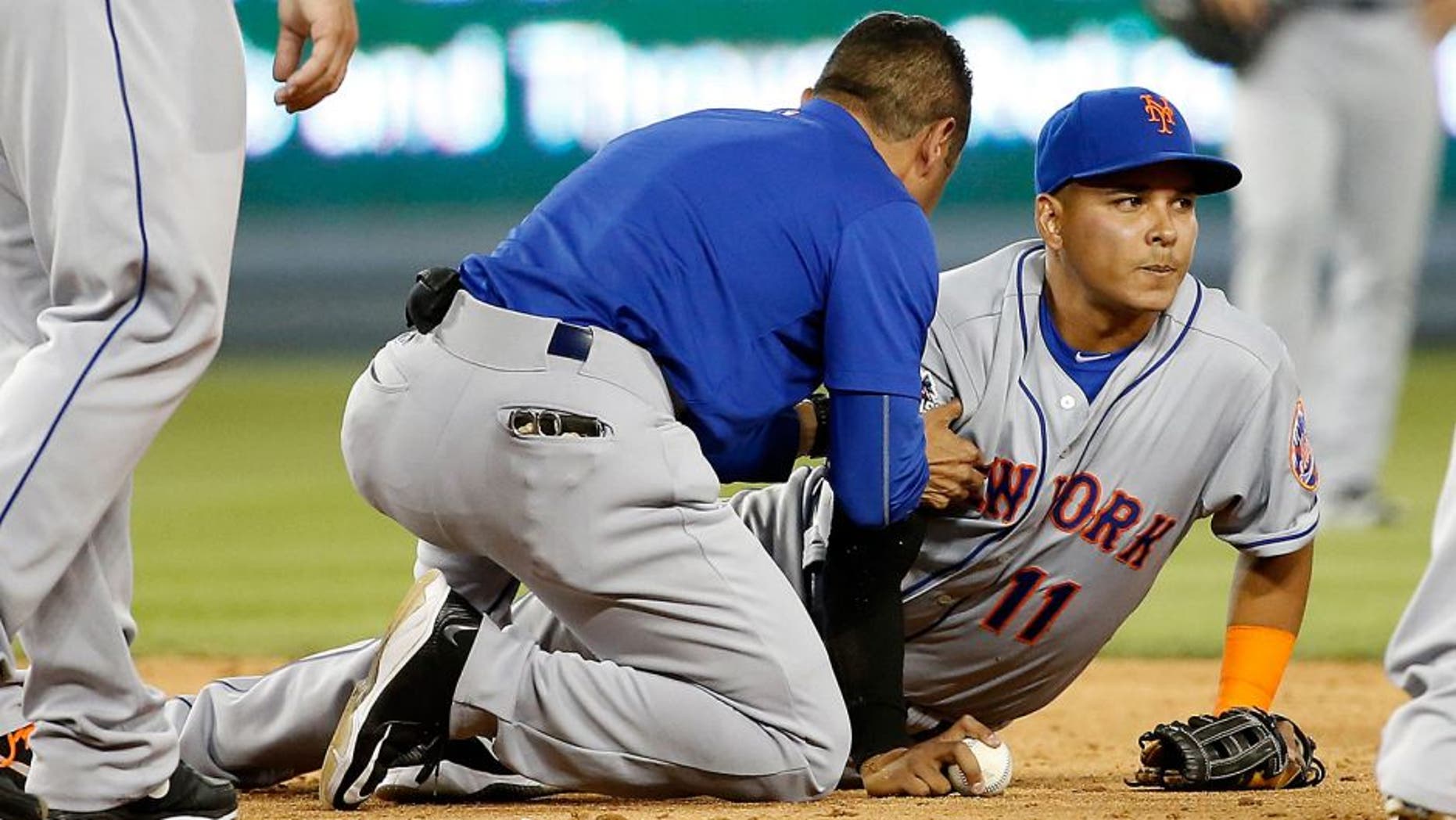 LOS ANGELES, CA - OCTOBER 10: Ruben Tejada #11 of the New York Mets is given medial attention on the field after sustaining an injury in the seventh inning on slide by Chase Utley #26 of the Los Angeles Dodgers in game two of the National League Division Series at Dodger Stadium on October 10, 2015 in Los Angeles, California. (Photo by Sean M. Haffey/Getty Images)