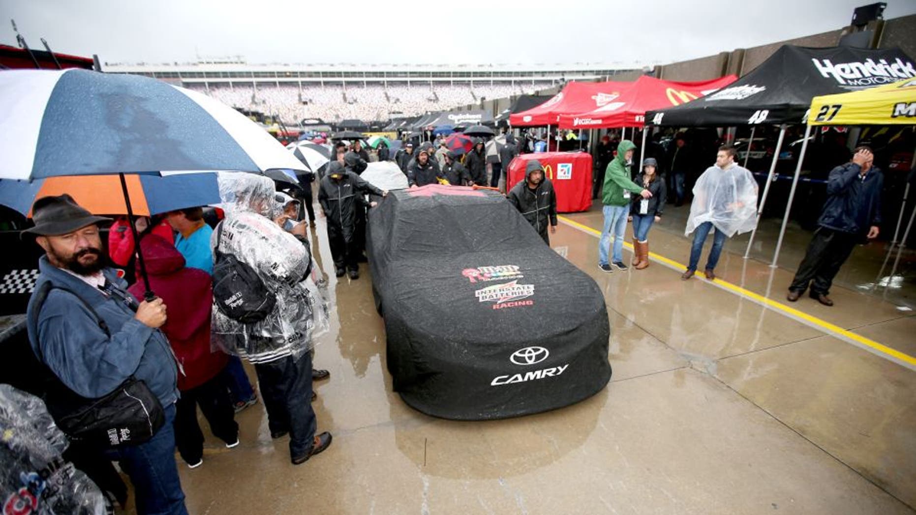 CHARLOTTE, NC - OCTOBER 10: The #18 M&M's Pretty In Pink Foundation Toyota of Kyle Busch sits covered in the rain prior to the NASCAR Sprint Cup Series Bank of America 500 at Charlotte Motor Speedway on October 10, 2015 in Charlotte, North Carolina. (Photo by Chris Graythen/NASCAR via Getty Images)