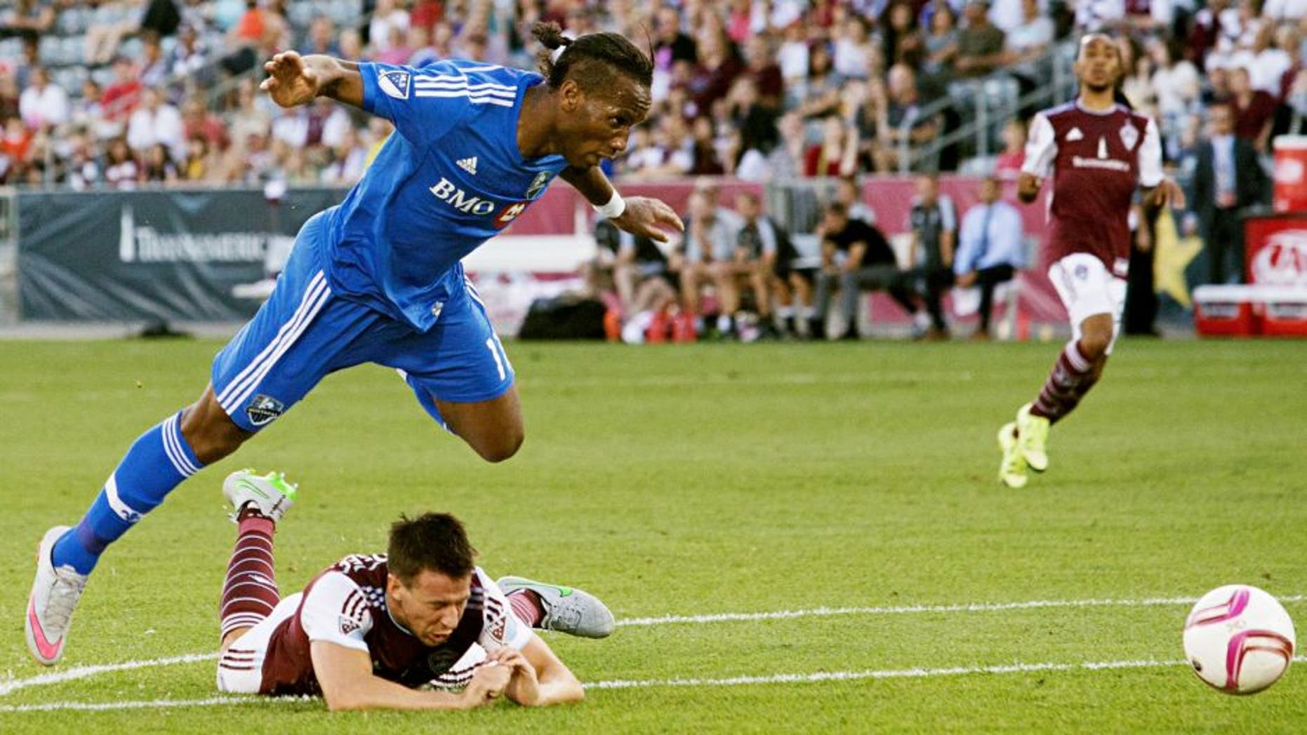 Oct 10, 2015; Commerce City, CO, USA; Montreal Impact forward Didier Drogba (11) leaps over a diving Colorado Rapids defender Sean St. Ledger (24) in the second half at Dick's Sporting Goods Park. The Impact defeated the Rapids 1-0. Mandatory Credit: Isaiah J. Downing-USA TODAY Sports