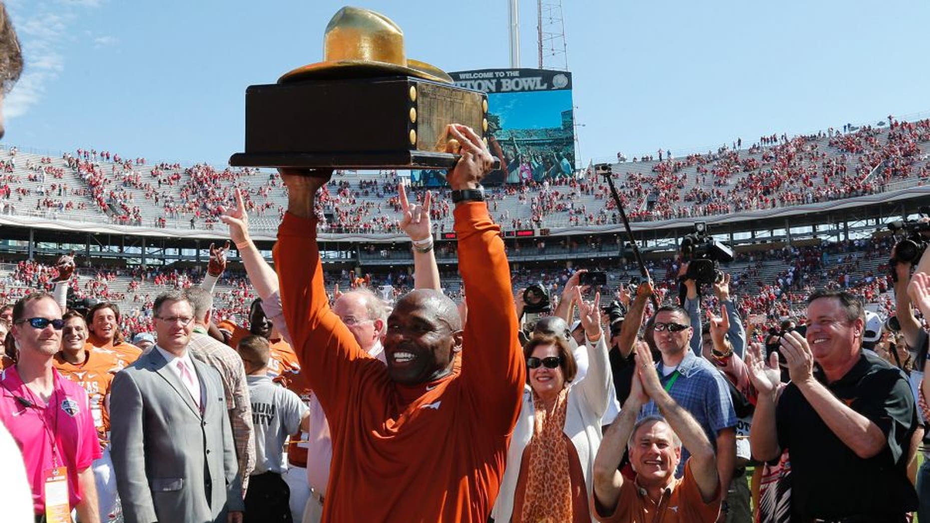 Oct 10, 2015; Dallas, TX, USA; Texas Longhorns head coach Charlie Strong celebrates with the golden hat trophy after a victory against the Oklahoma Sooners during Red River rivalry at Cotton Bowl Stadium. Texas beat Oklahoma 24-17. Mandatory Credit: Matthew Emmons-USA TODAY Sports