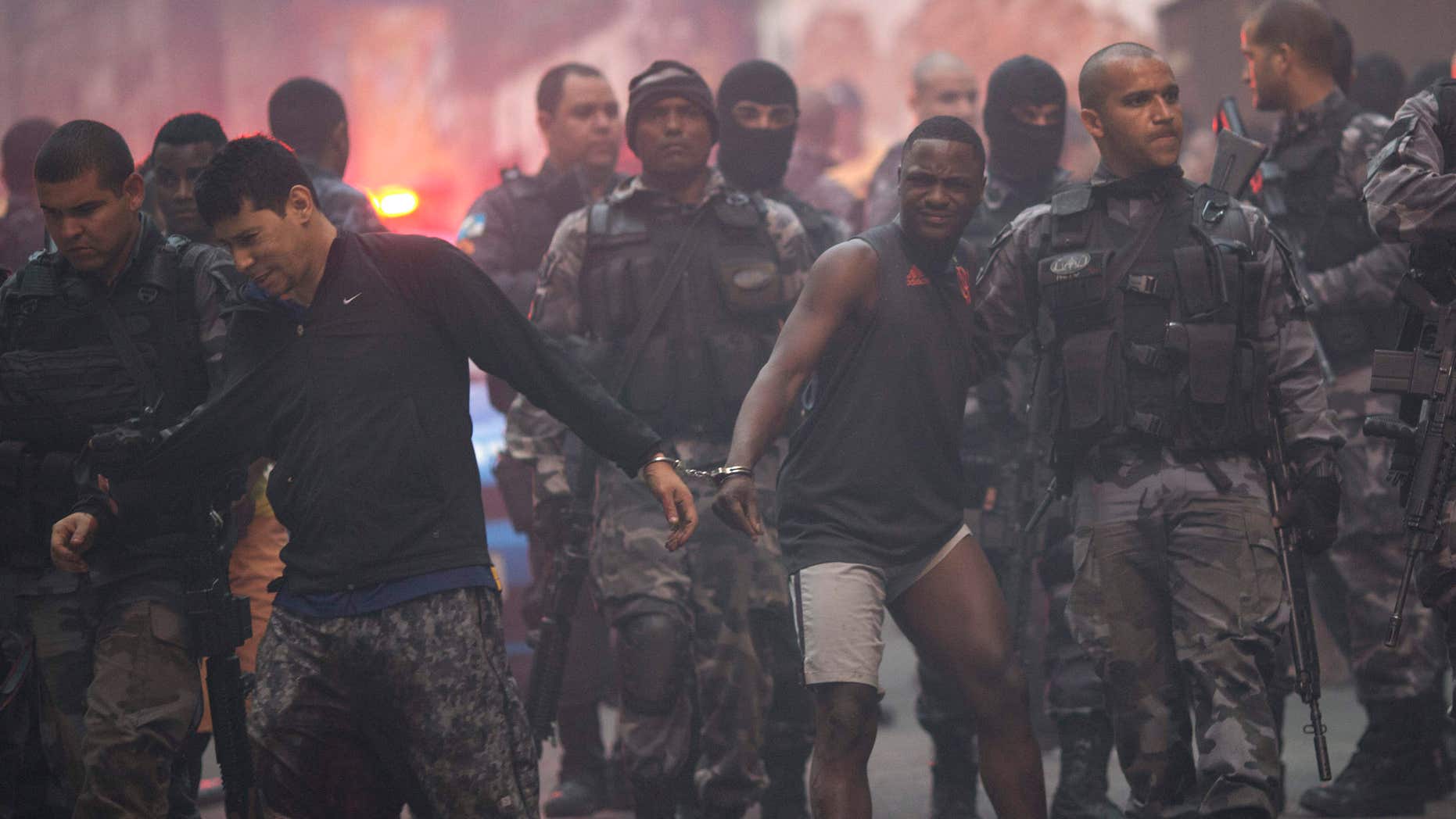 Oct. 10, 2016: Police move a couple of handcuffed, recently detained men at Pavao Pavaozinho slum during a police operation in Rio de Janeiro, Brazil.