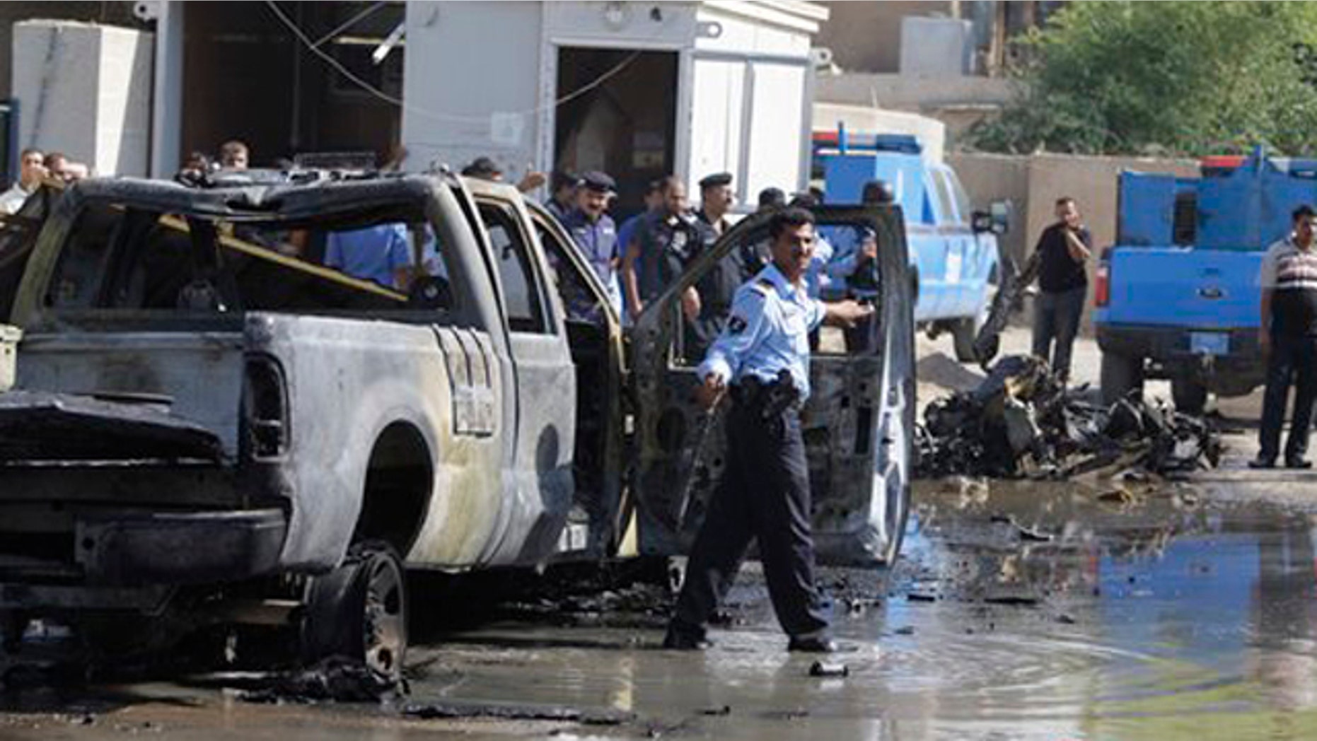 Oct. 12: Iraqi security forces stand guard in front of a police station at Hurriyah neighborhood in Baghdad.