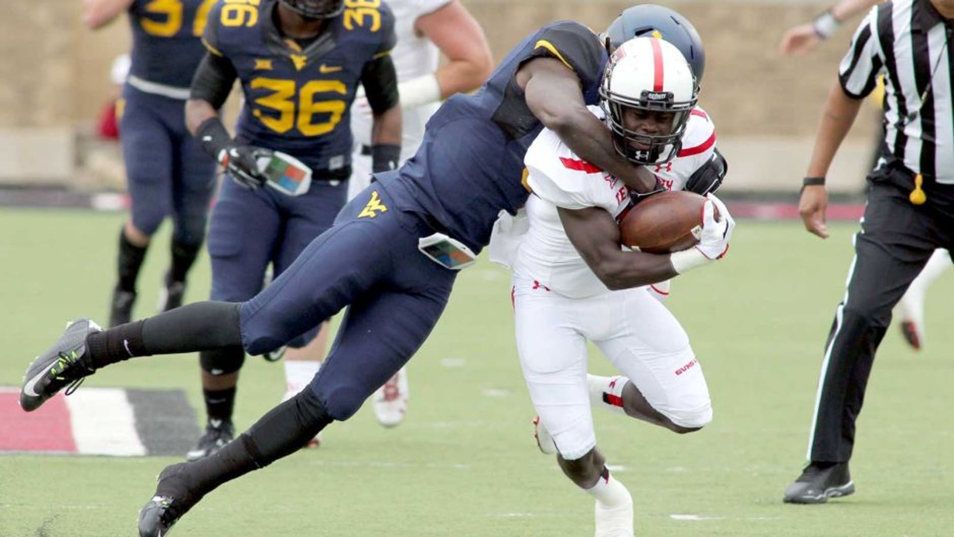 Oct 11, 2014; Lubbock, TX, USA; Texas Tech Red Raiders wide receiver Jakeem Grant (11) is tackled by West Virginia Mountaineers defensive back K.J. Dillion (9) in the first half at Jones AT&T Stadium. Mandatory Credit: Michael C. Johnson-USA TODAY Sports