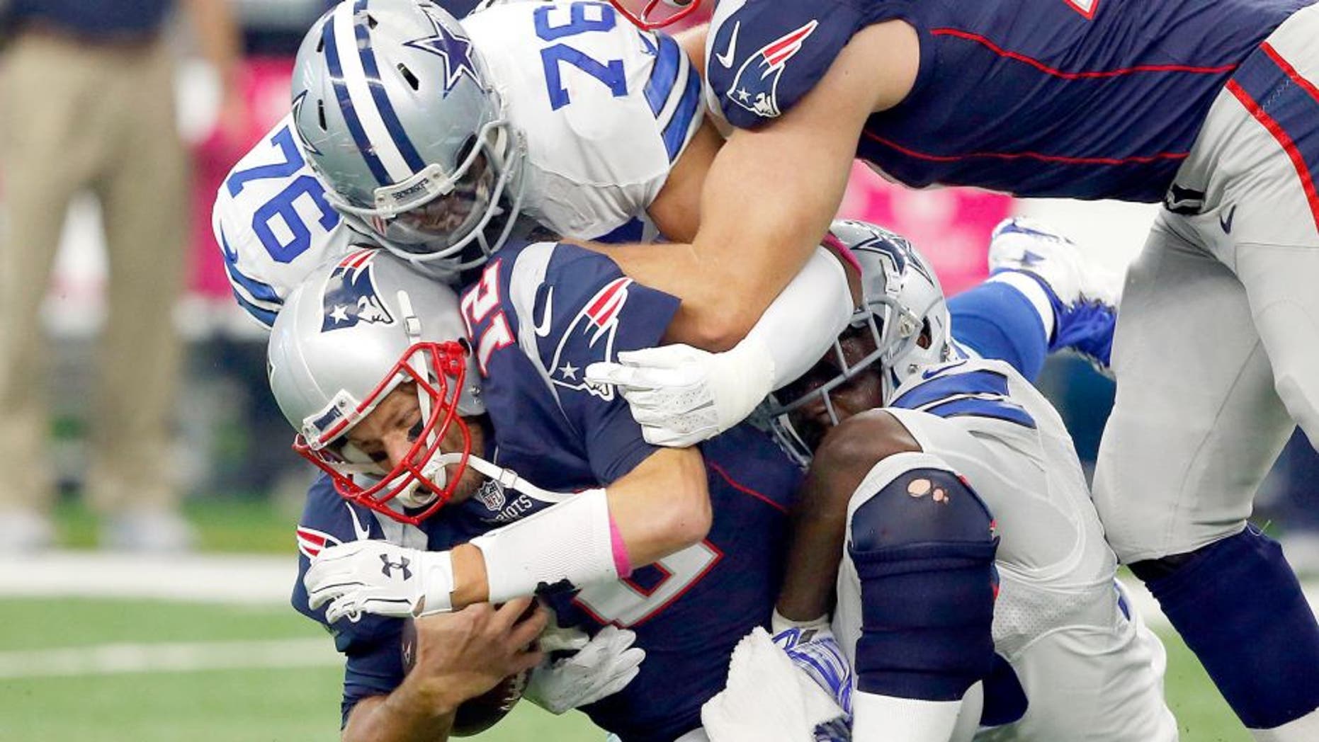 Oct 11, 2015; Arlington, TX, USA; New England Patriots quarterback Tom Brady (12) is sacked by Dallas Cowboys linebacker Rolando McClain (55) and defensive end Greg Hardy (76) at AT&T Stadium. Patriots tackle Nate Solder (77) trying to block out Hardy (76). Mandatory Credit: Erich Schlegel-USA TODAY Sports