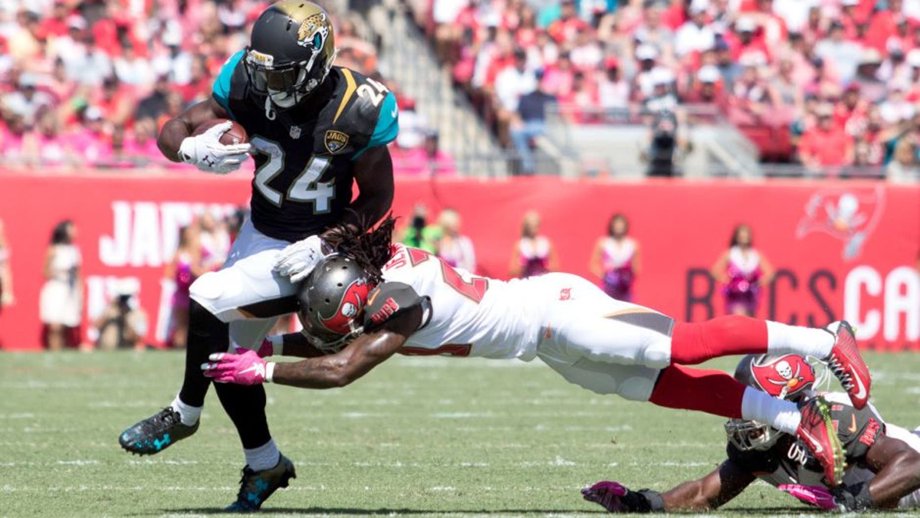 Oct 11, 2015; Tampa, FL, USA; Tampa Bay Buccaneers cornerback Tim Jennings (right) tackles Jacksonville Jaguars running back T.J. Yeldon (24) during the first quarter at Raymond James Stadium. Mandatory Credit: Logan Bowles-USA TODAY Sports