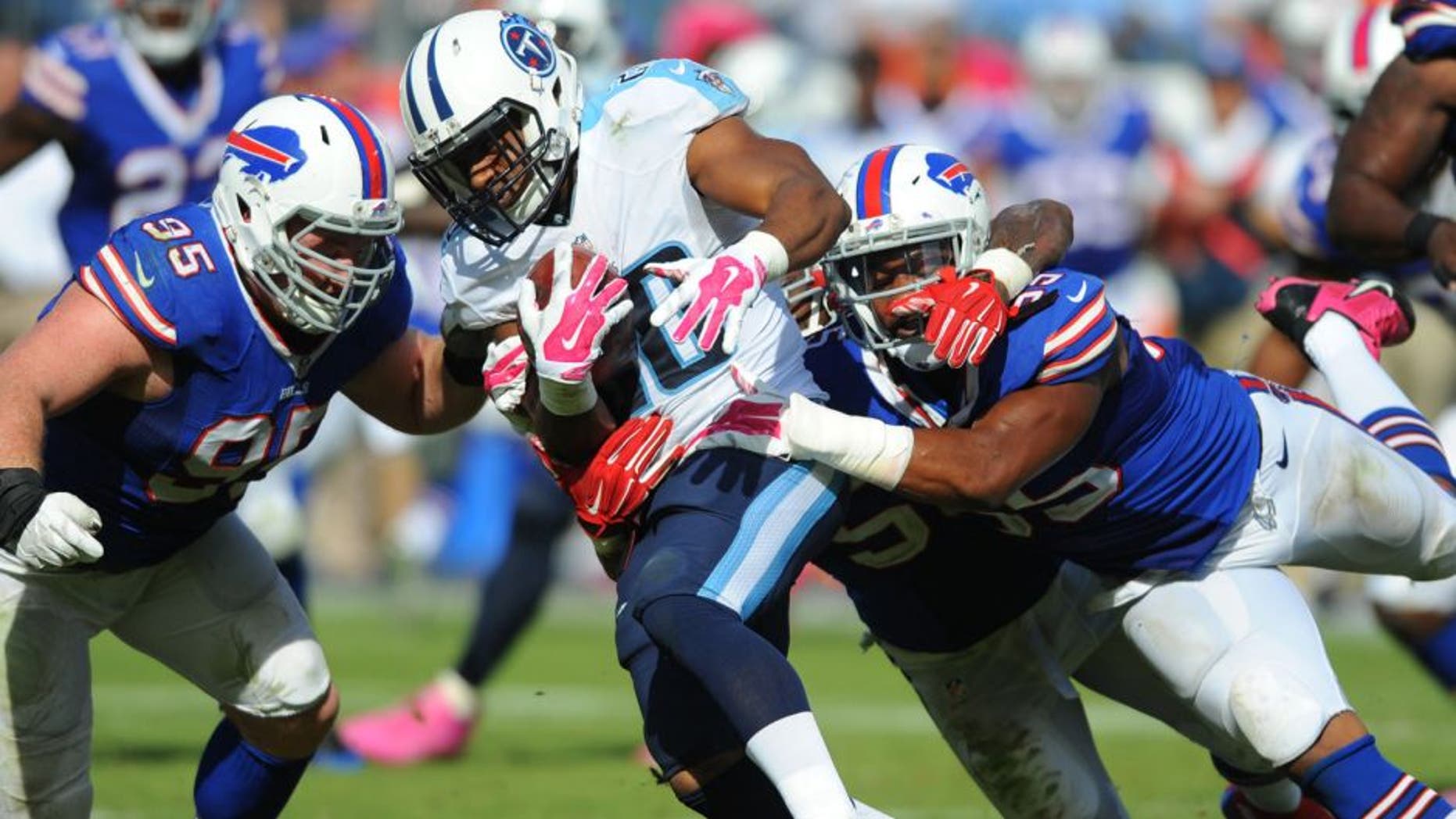 Oct 11, 2015; Nashville, TN, USA; Tennessee Titans running back Bishop Sankey (20) is tackled by Buffalo Bills defensive end Jerry Hughes (55) and defensive tackle Kyle Williams (95) during the second half at Nissan Stadium. The Bills won 14-13. Mandatory Credit: Christopher Hanewinckel-USA TODAY Sports
