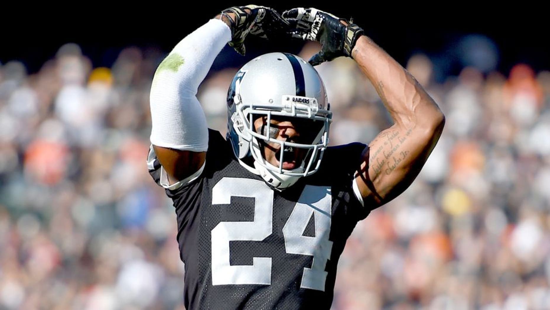OAKLAND, CA - NOVEMBER 09: Charles Woodson #24 of the Oakland Raiders celebrates after the Raiders stopped the Denver Broncos on third an goal during the first quarter at O.co Coliseum on November 9, 2014 in Oakland, California. (Photo by Thearon W. Henderson/Getty Images)