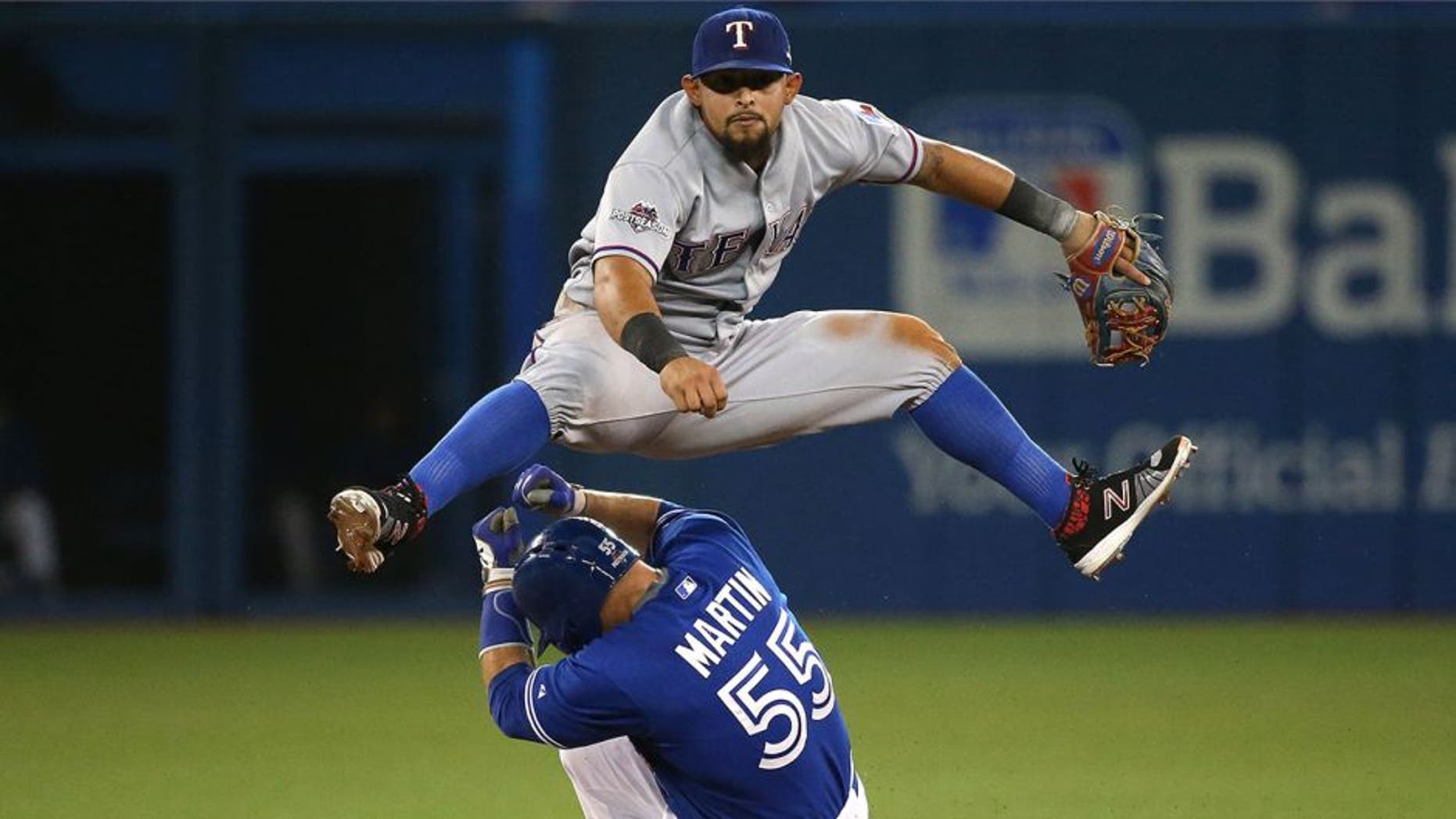 TORONTO, ON- OCTOBER 9: Joey Gallo leaps over Russell Martin turning a double play. The Toronto Blue Jays and Texas Rangers play game two of the MLB American League Division Series . at Rogers Centre in Toronto. October 9, 2015. (Steve Russell/Toronto Star via Getty Images)