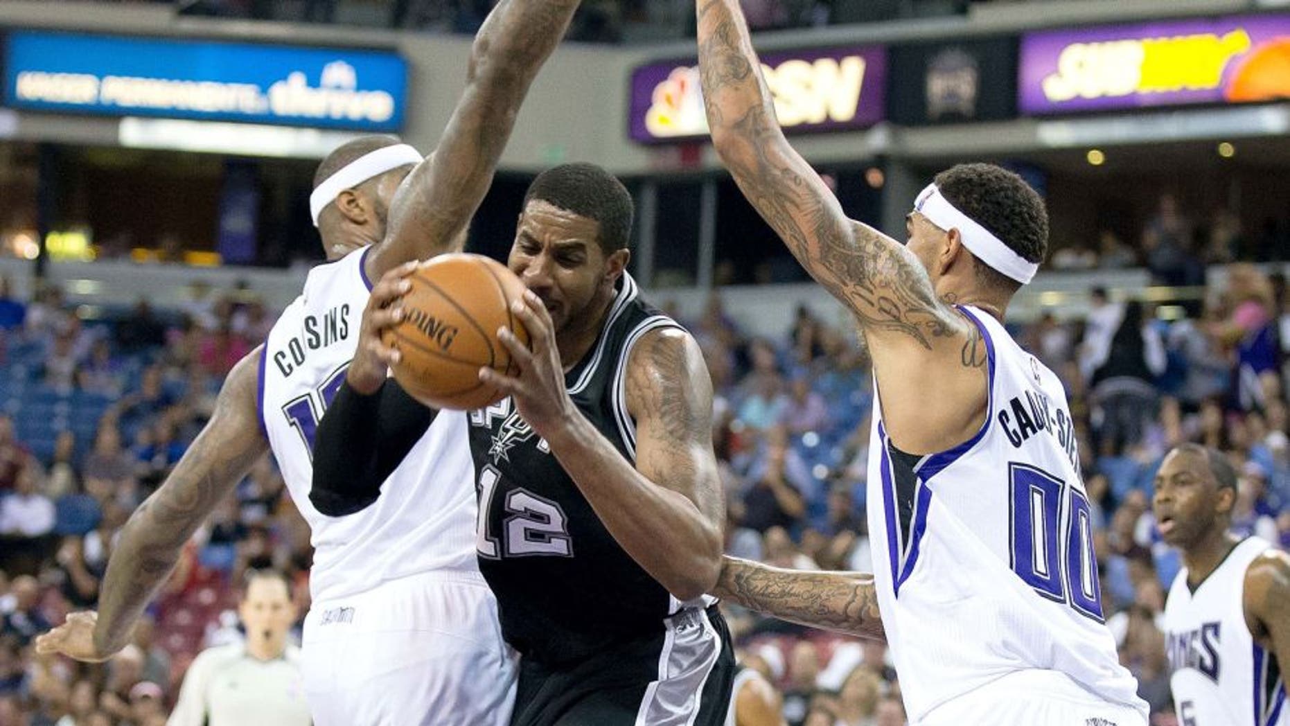 Oct 8, 2015; Sacramento, CA, USA; Sacramento Kings center DeMarcus Cousins (15) and center Willie Cauley-Stein (00) defend San Antonio Spurs forward LaMarcus Aldridge (12) during the third quarter at Sleep Train Arena. The Kings won 95-92. Mandatory Credit: Kelley L Cox-USA TODAY Sports
