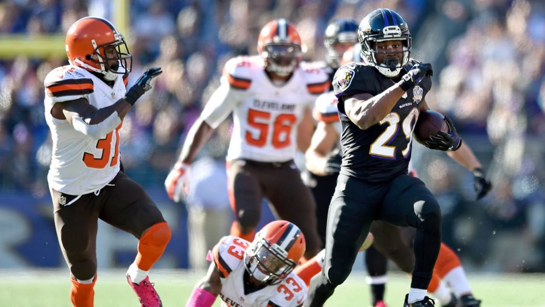 Baltimore Ravens running back Justin Forsett, right, outruns Cleveland Browns defenders in the second half of an NFL football game, Sunday, Oct. 11, 2015, in Baltimore. (AP Photo/Gail Burton)