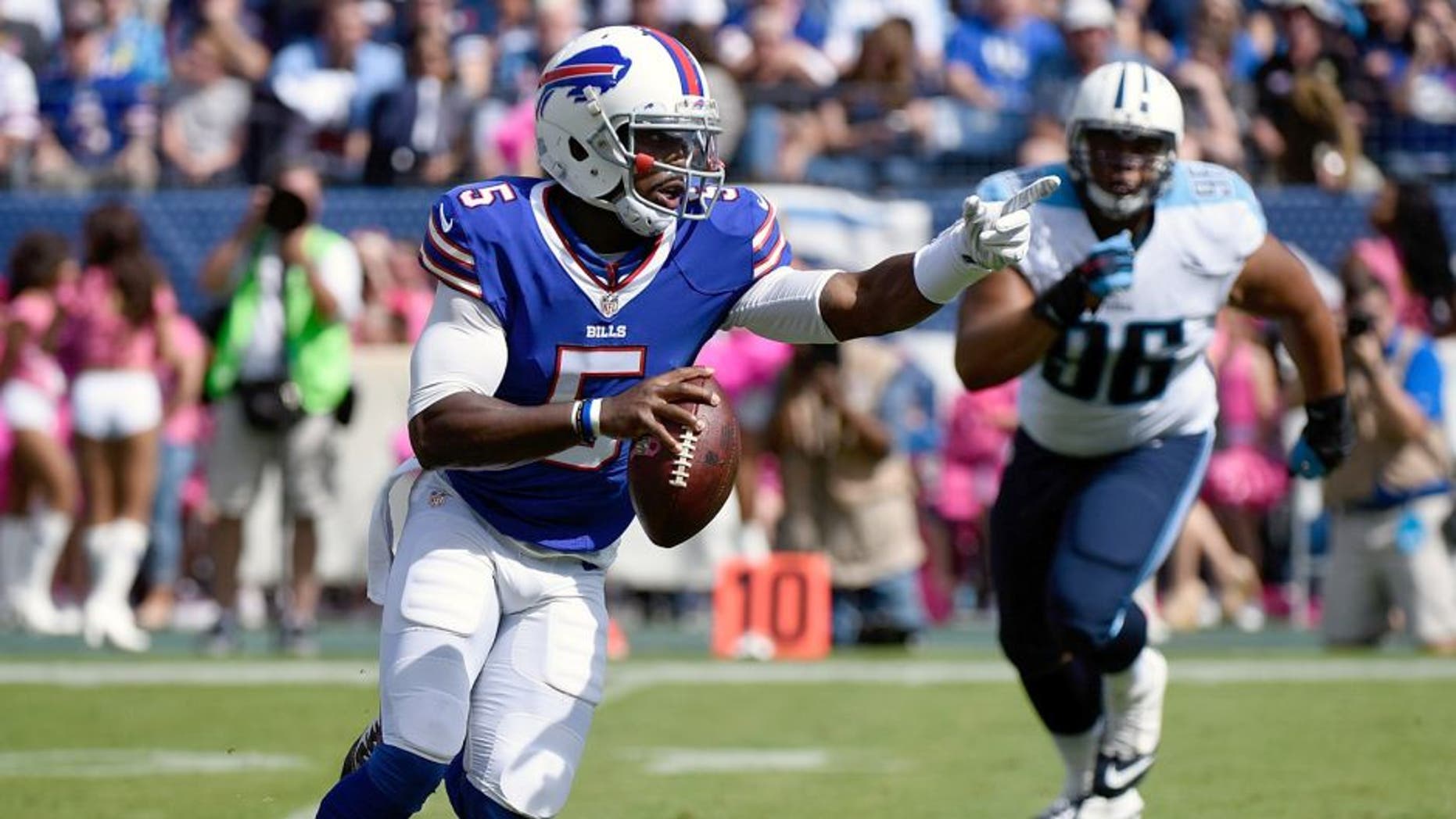 NASHVILLE, TN - OCTOBER 11: Quarterback Tyrod Taylor #5 of the Buffalo Bills rushes out of the reach of Al Woods #96 of the Tennessee Titans during the first half of a game at Nissan Stadium on October 11, 2015 in Nashville, Tennessee. (Photo by Frederick Breedon/Getty Images)