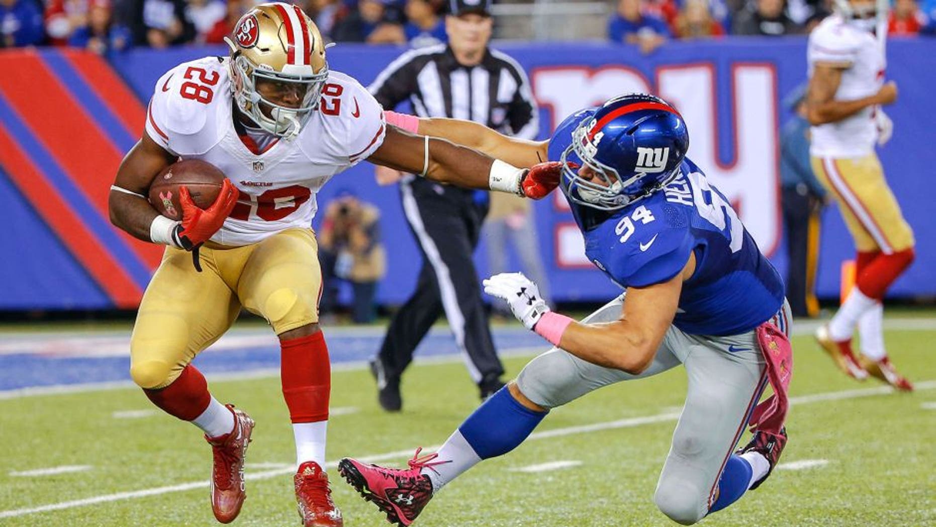 Oct 11, 2015; East Rutherford, NJ, USA; San Francisco 49ers running back Carlos Hyde (28) carries the ball as New York Giants outside linebacker Mark Herzlich (94) defends during the third quarter at MetLife Stadium. The Giants won 30-27. Mandatory Credit: Jim O'Connor-USA TODAY Sports